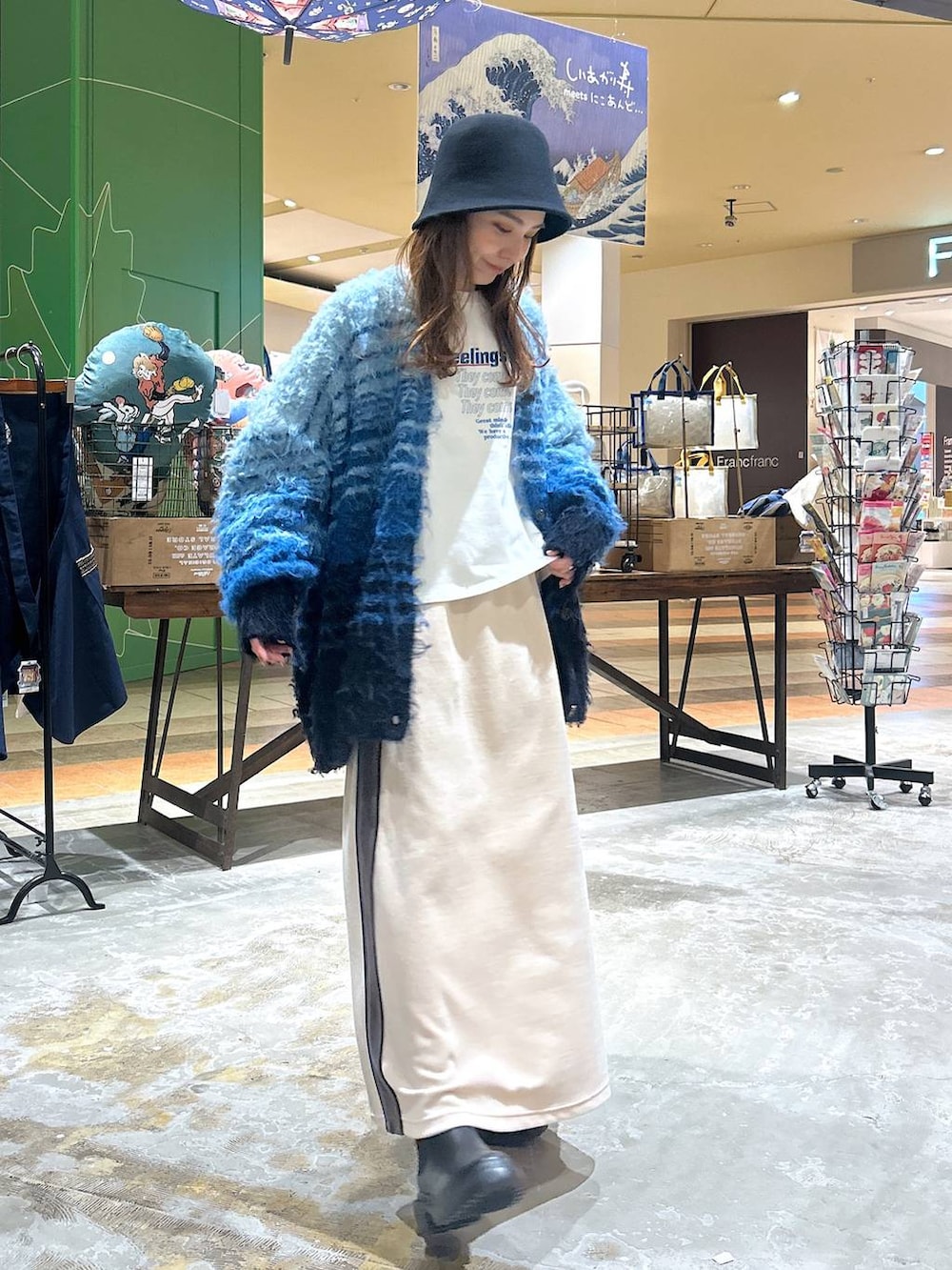 ブラック系のブーツ、ホワイト系のその他トップス、ベージュ系のスカートを着用したレディースの冬コーディネートの3枚目の写真