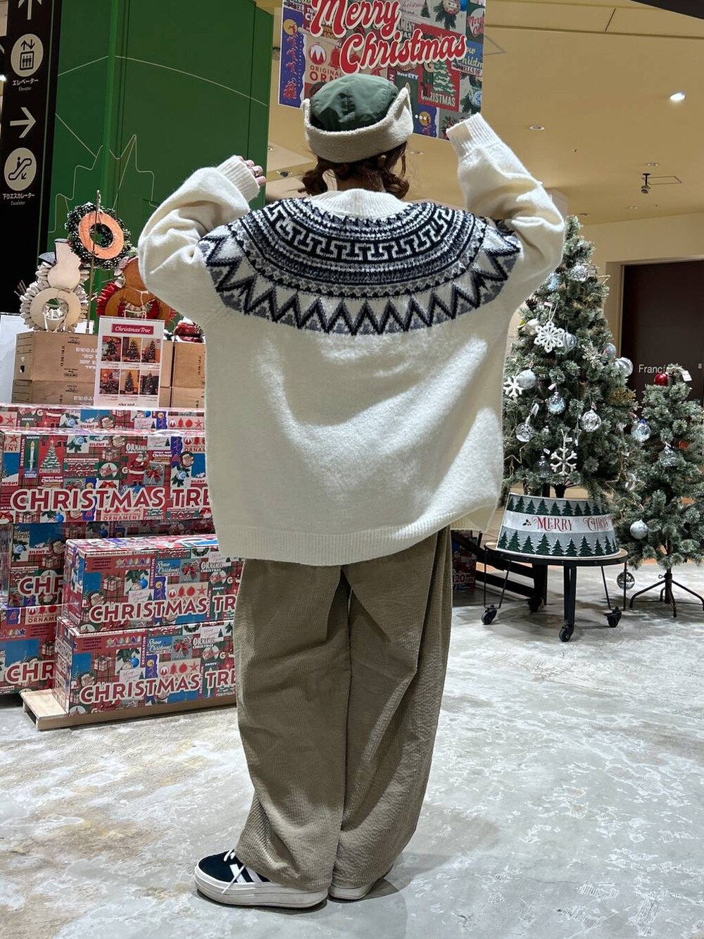 ベージュ系のニット/セーター、イエロー系のその他パンツ、グリーン系のキャップを着用したレディースの冬コーディネートの3枚目の写真