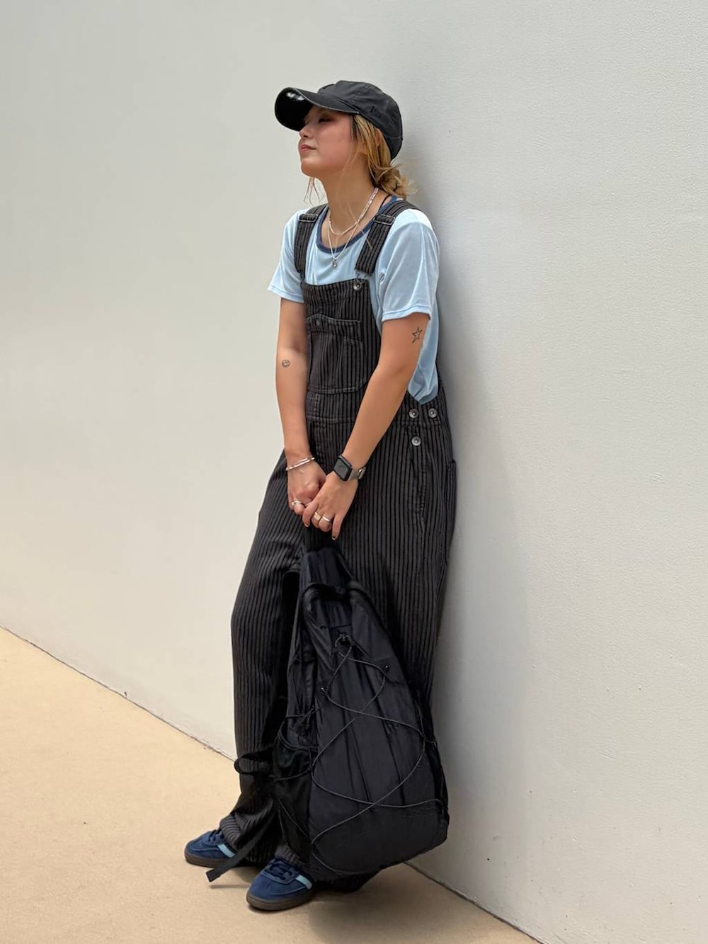 ブラック系のバックパック/リュック、ブルー系のTシャツ/カットソー、グレー系のサロペット/オーバーオールを着用したレディースの夏コーディネートの4枚目の写真
