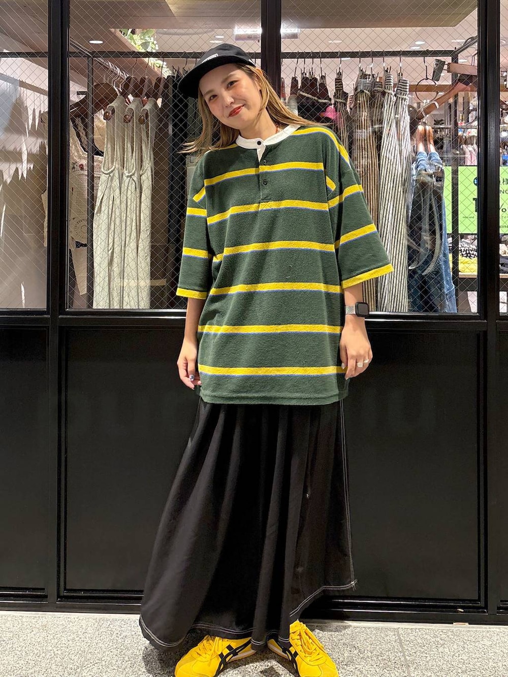 グリーン系のTシャツ/カットソー、ブラック系のキャップを着用したレディースの夏コーディネートの2枚目の写真