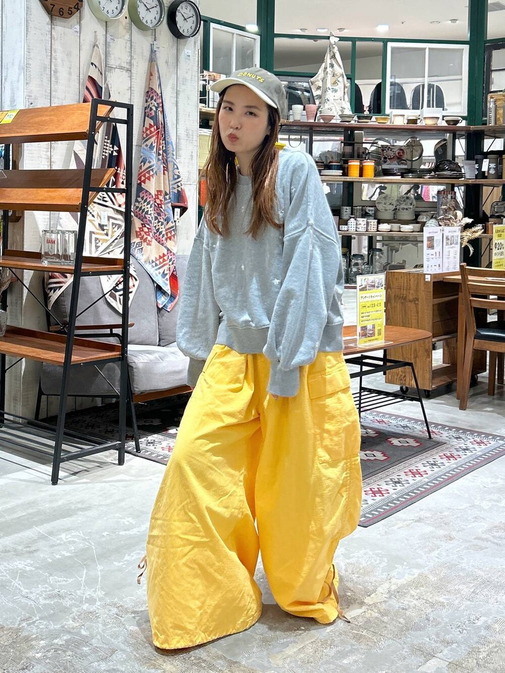 グレー系のスウェット、グリーン系のキャップを着用したレディースの冬コーディネートの4枚目の写真