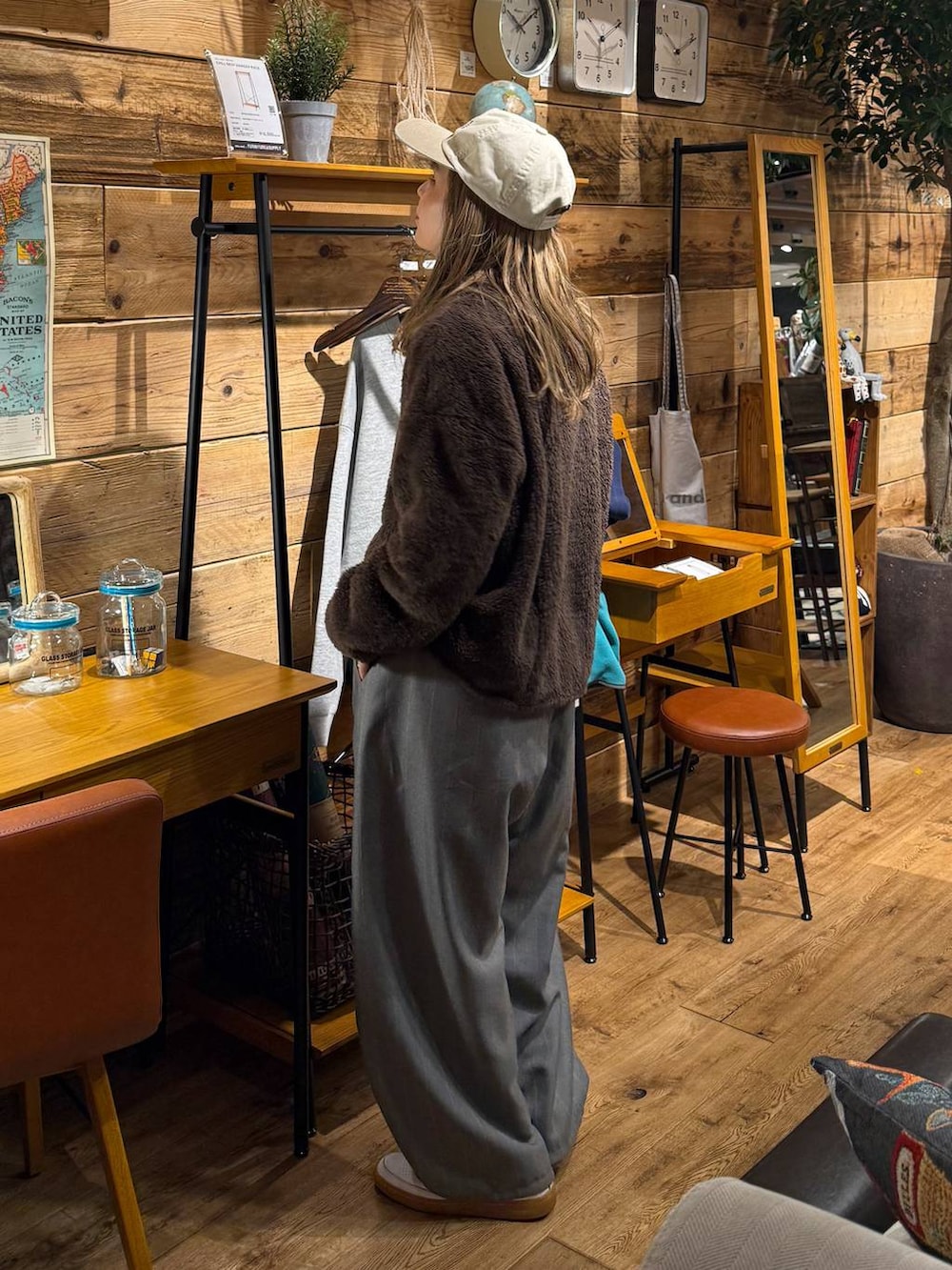 ブラウン系のポロシャツ、ホワイト系のキャップを着用したレディースの冬コーディネートの4枚目の写真