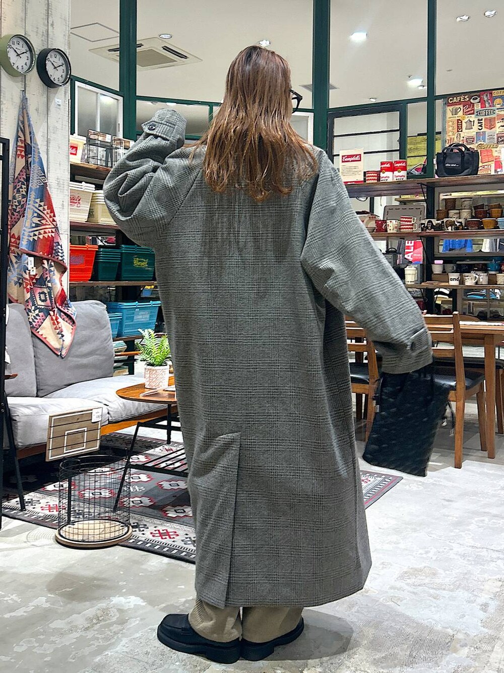 ブラック系のショルダーバッグ、ブラック系のローファー、グレー系のステンカラーコートを着用したレディースの冬コーディネートの4枚目の写真