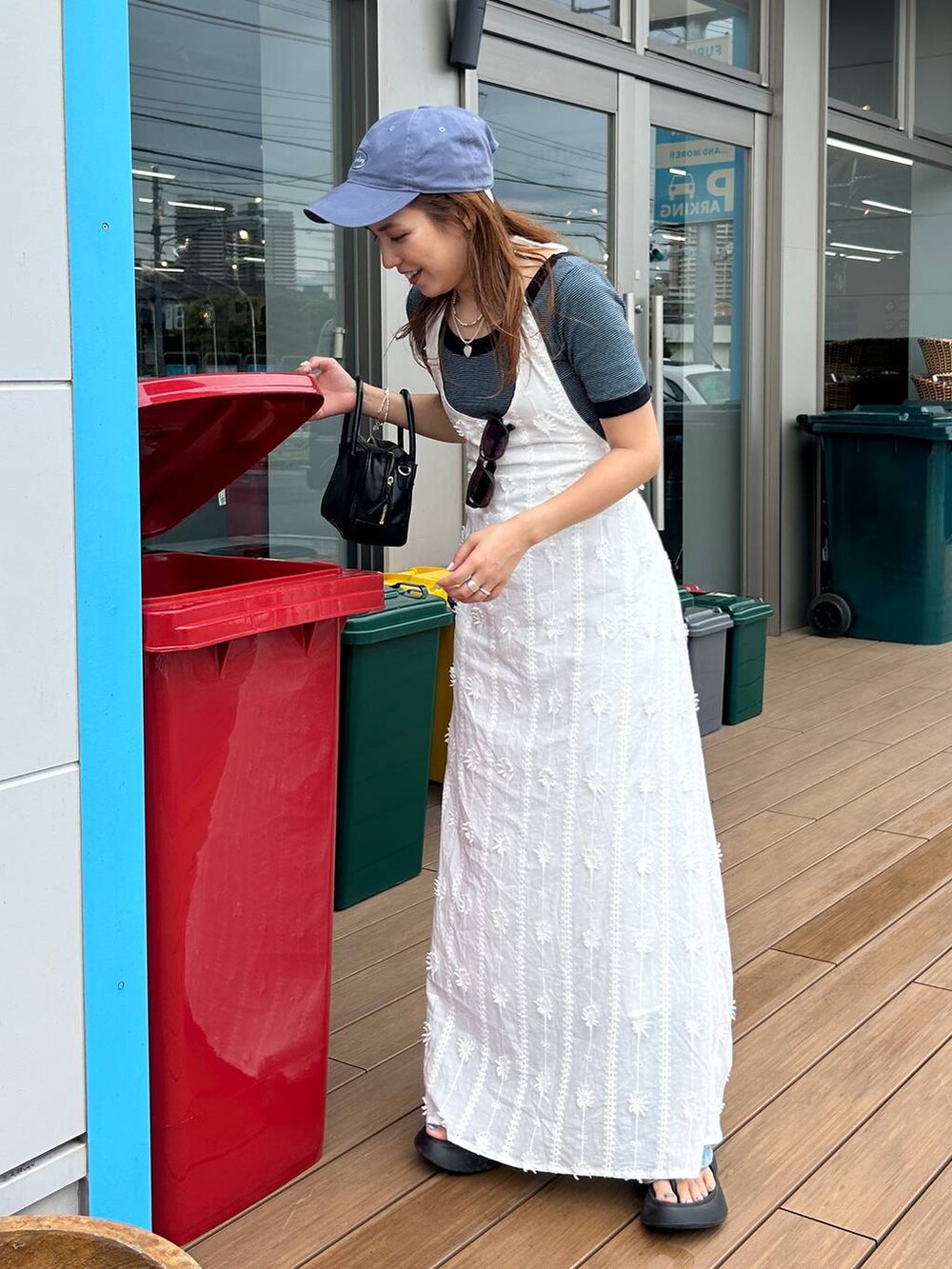 ブラック系のサンダル、ホワイト系のワンピース、ブルー系のその他パンツを着用したレディースの春コーディネートの2枚目の写真