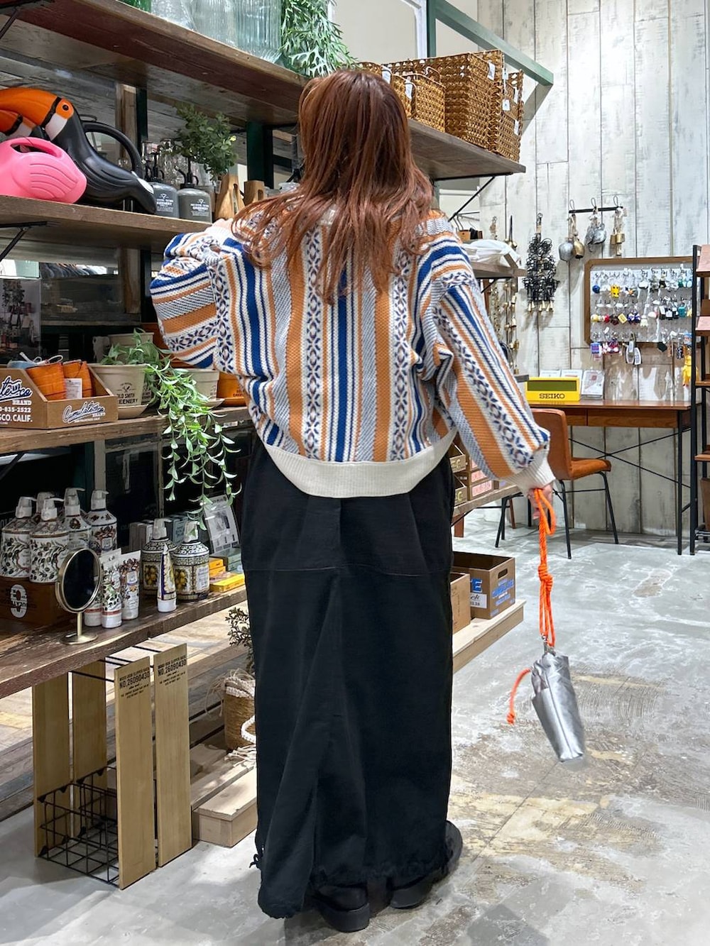 ブラック系のローファー、オレンジ系のカーディガン/ボレロ、グレー系のショルダーバッグを着用したレディースの冬コーディネートの4枚目の写真