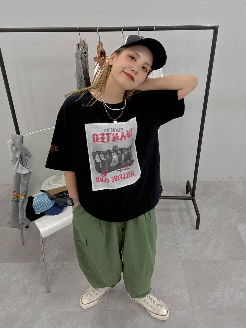 グリーン系のカーゴパンツ、ブラック系のTシャツ/カットソー、ブラック系のキャップを着用したレディースの夏コーディネートの2枚目の写真
