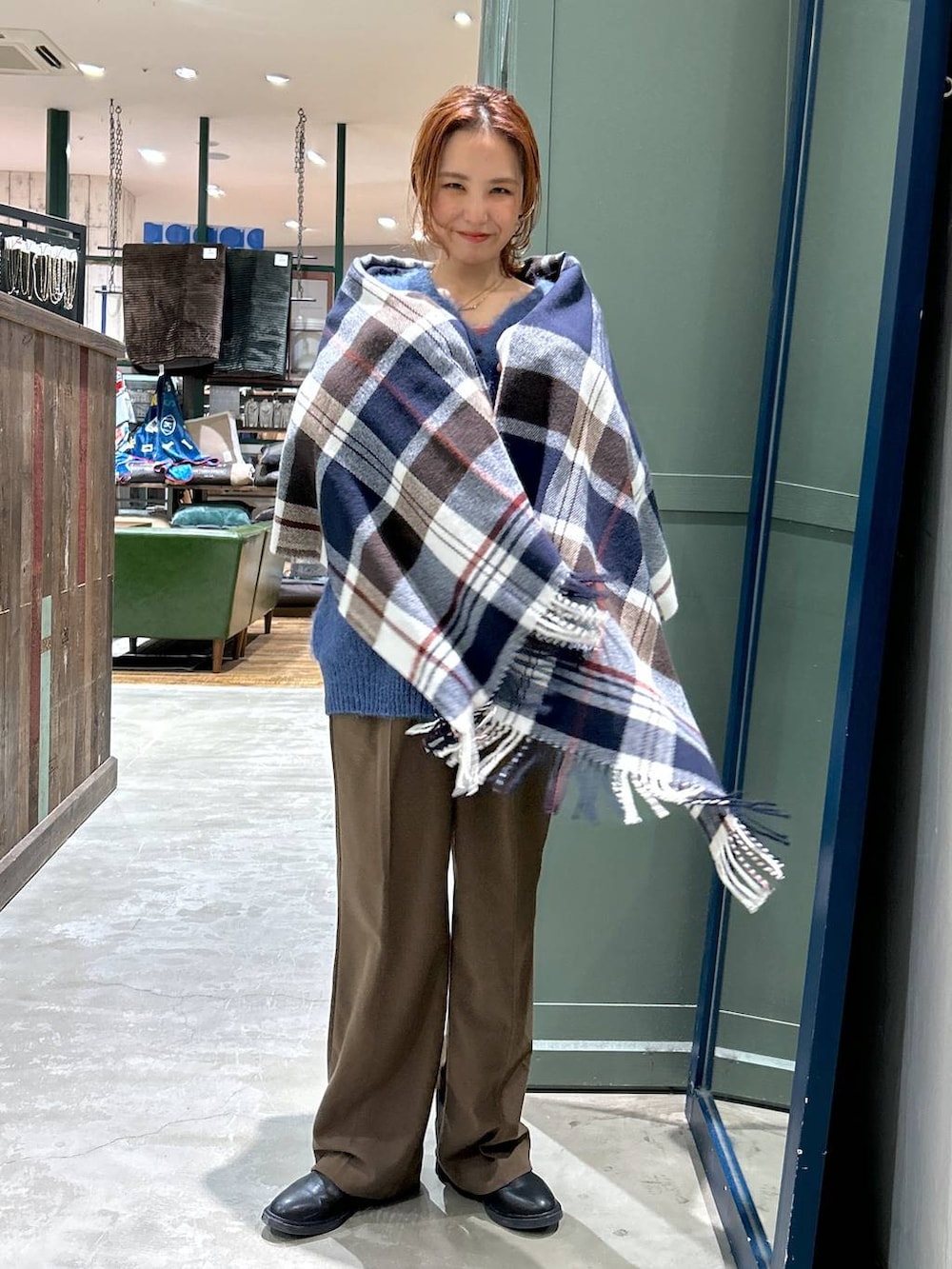 ブラウン系のその他パンツ、ブルー系のカーディガン/ボレロ、ブルー系のストール/ショールを着用したレディースの冬コーディネートの2枚目の写真