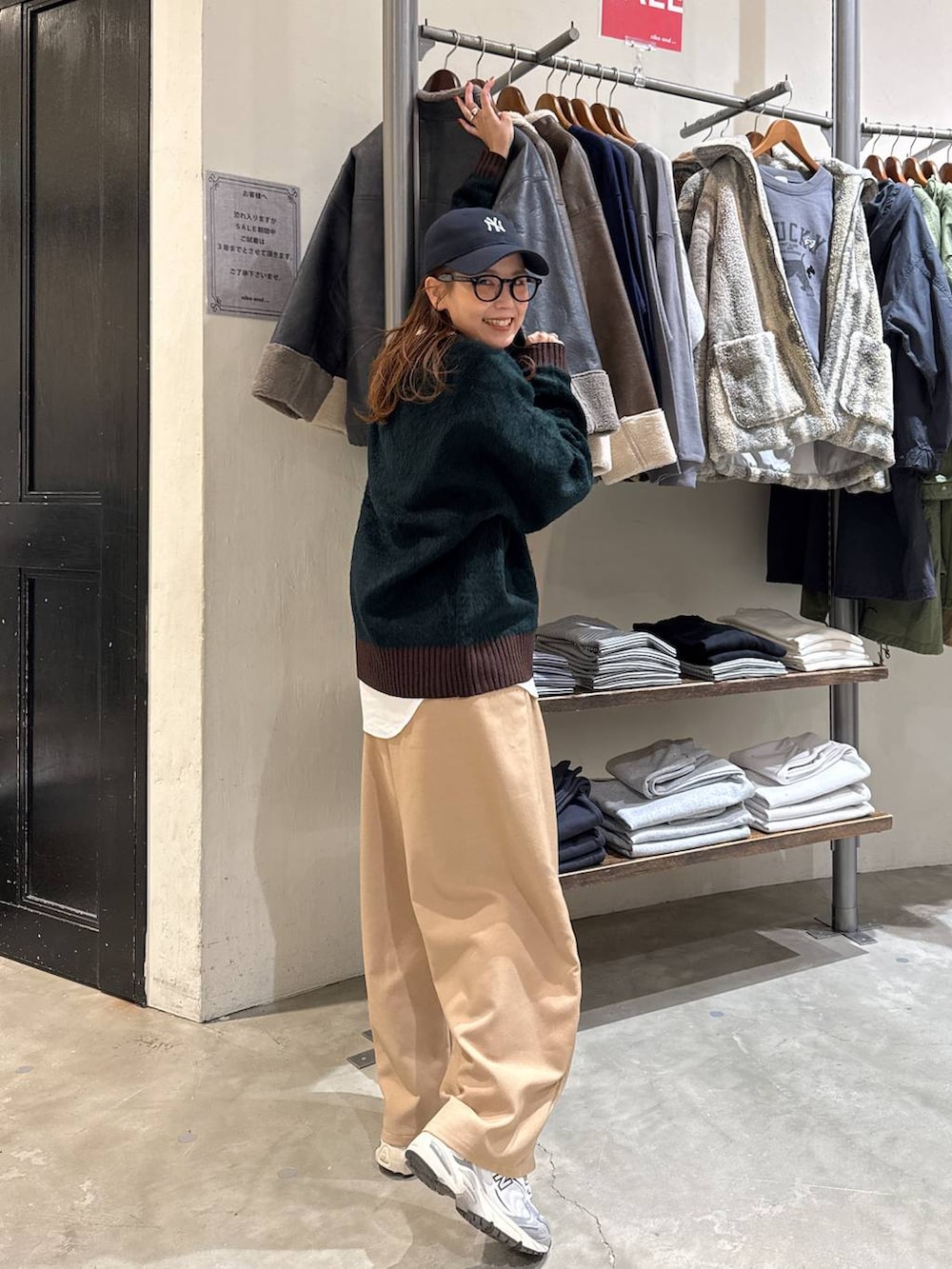 グレー系のブルゾン、ホワイト系のTシャツ/カットソー、グリーン系のニット/セーターを着用したレディースの冬コーディネートの4枚目の写真