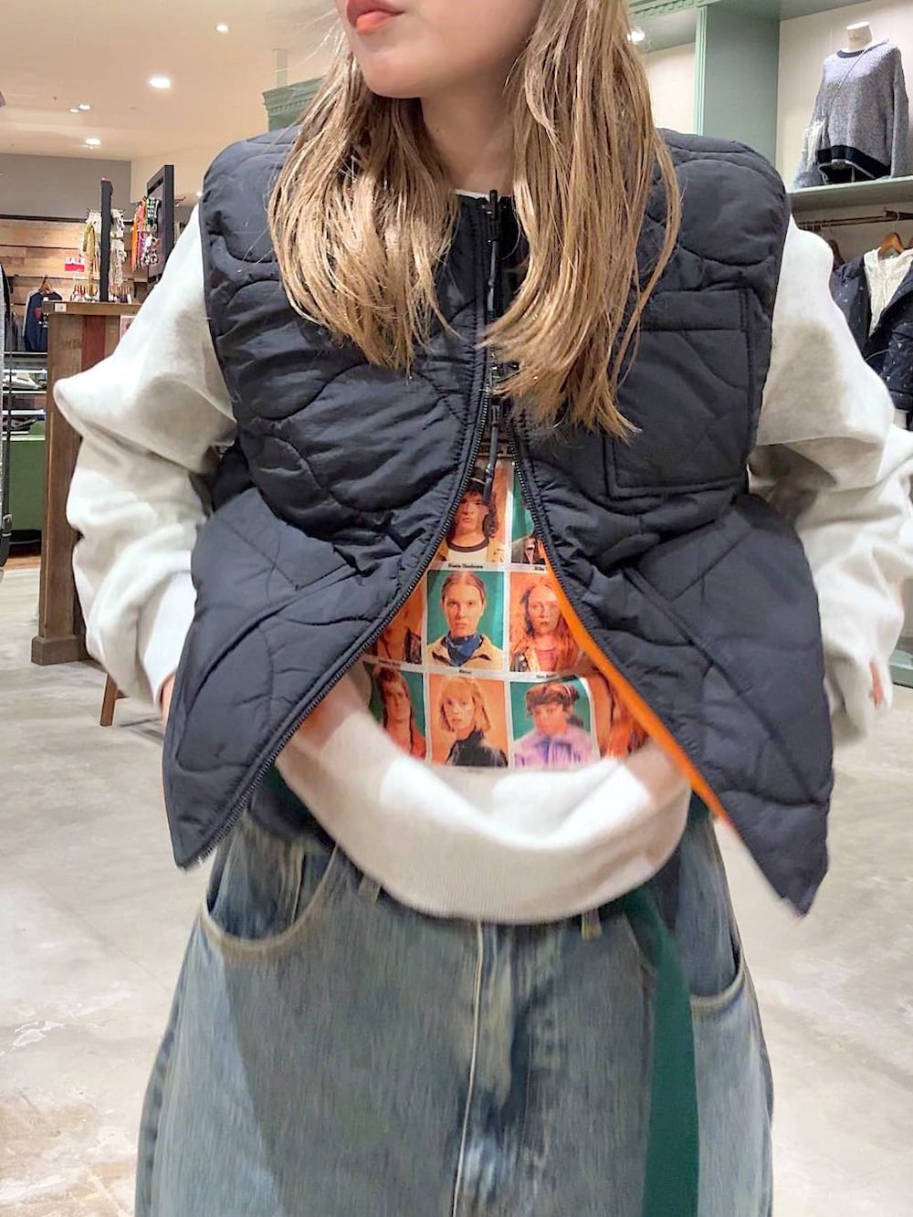 ブラック系のベスト、ベージュ系のスウェット、ブルー系のデニムパンツを着用したレディースの冬コーディネートの4枚目の写真