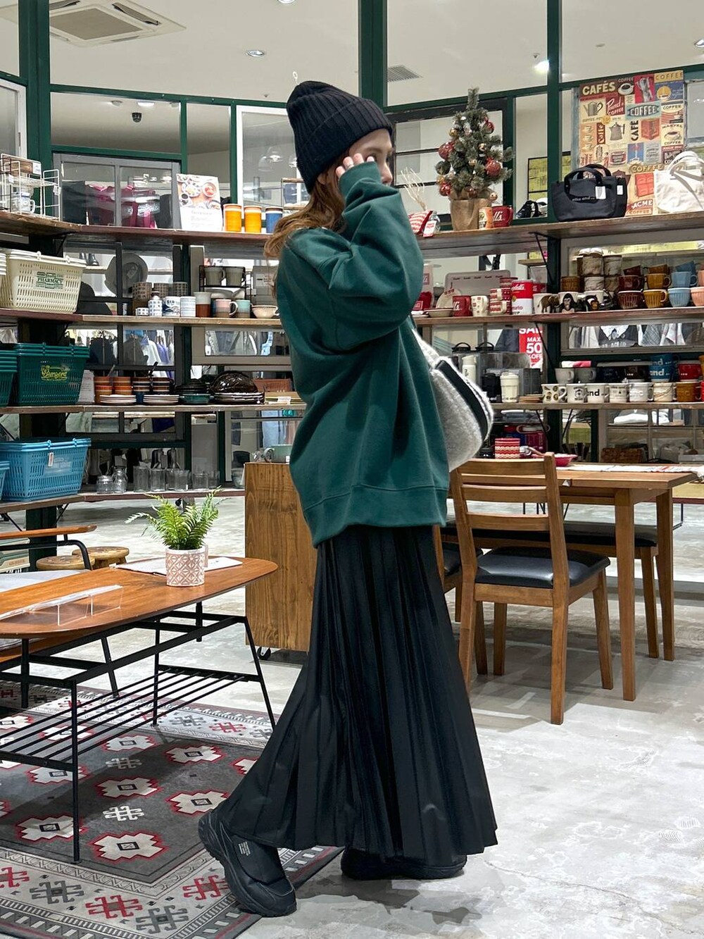 グリーン系のその他トップス、ベージュ系のショルダーバッグ、ブラック系のスカートを着用したレディースの冬コーディネートの2枚目の写真