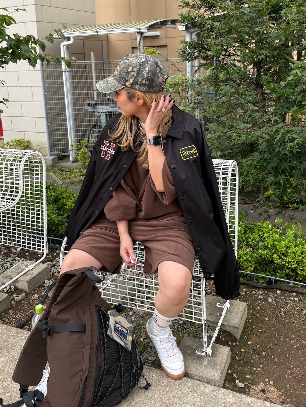 グリーン系のキャップを着用したレディースの夏コーディネートの2枚目の写真