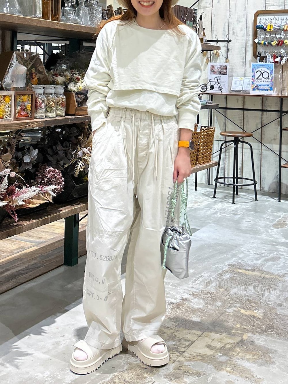 シルバー系のショルダーバッグ、ホワイト系のTシャツ/カットソー、ベージュ系のその他パンツを着用したレディースの春コーディネートの3枚目の写真