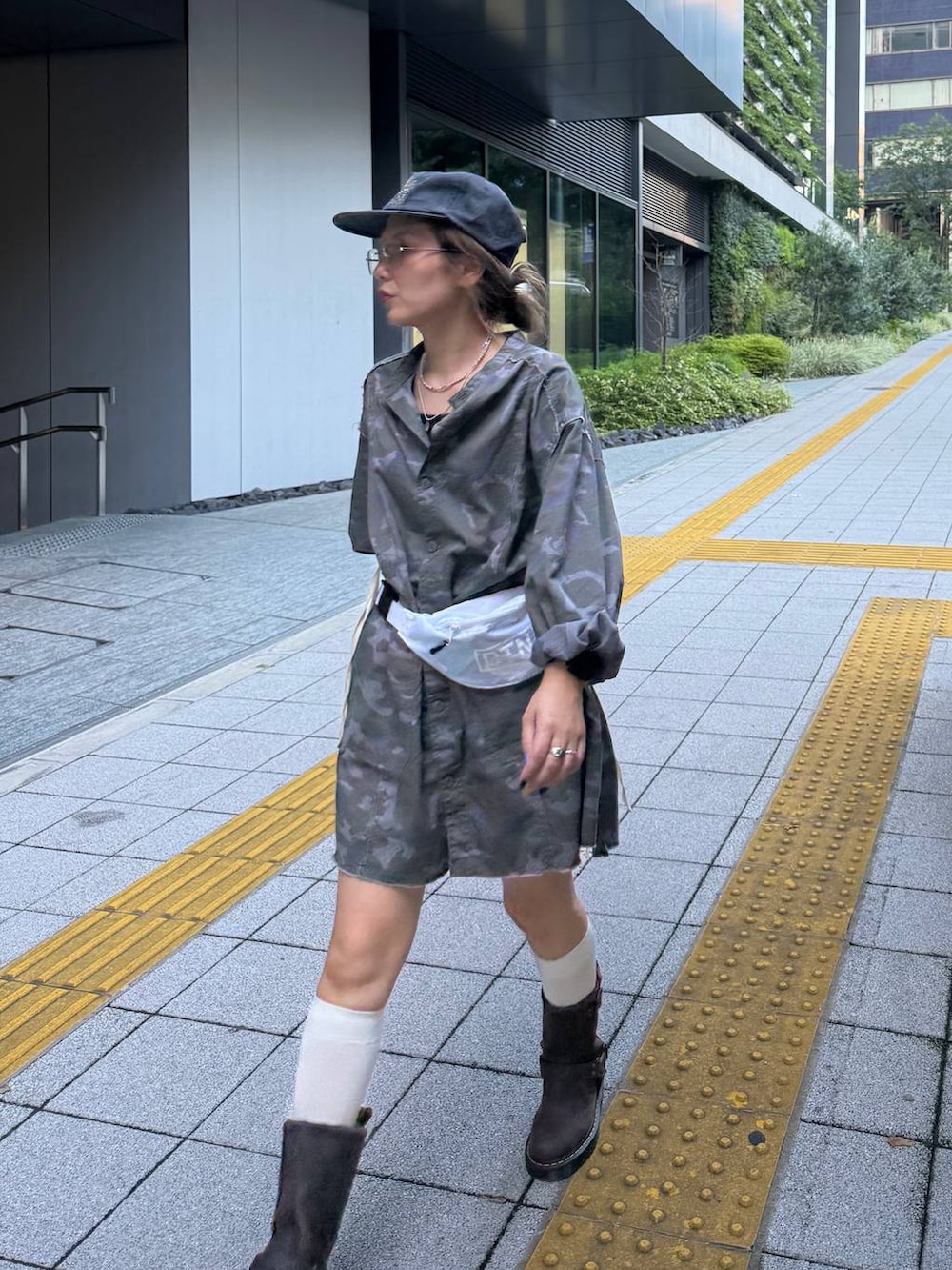 グリーン系のワンピース、グレー系のキャップを着用したレディースの秋コーディネートの2枚目の写真