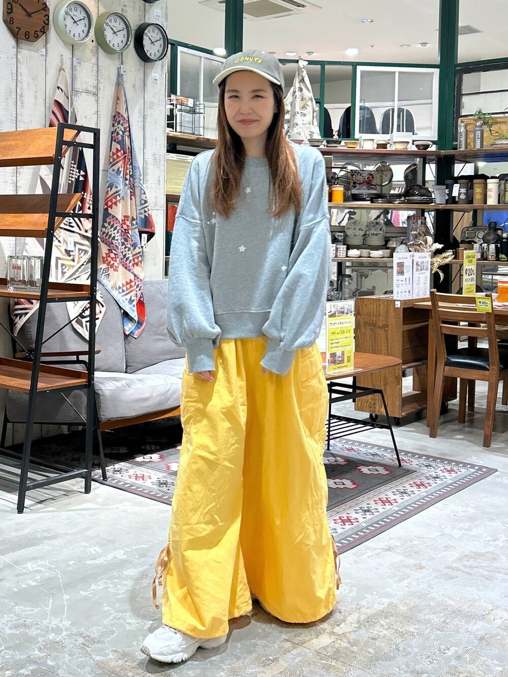 グレー系のスウェット、グリーン系のキャップを着用したレディースの冬コーディネートの2枚目の写真