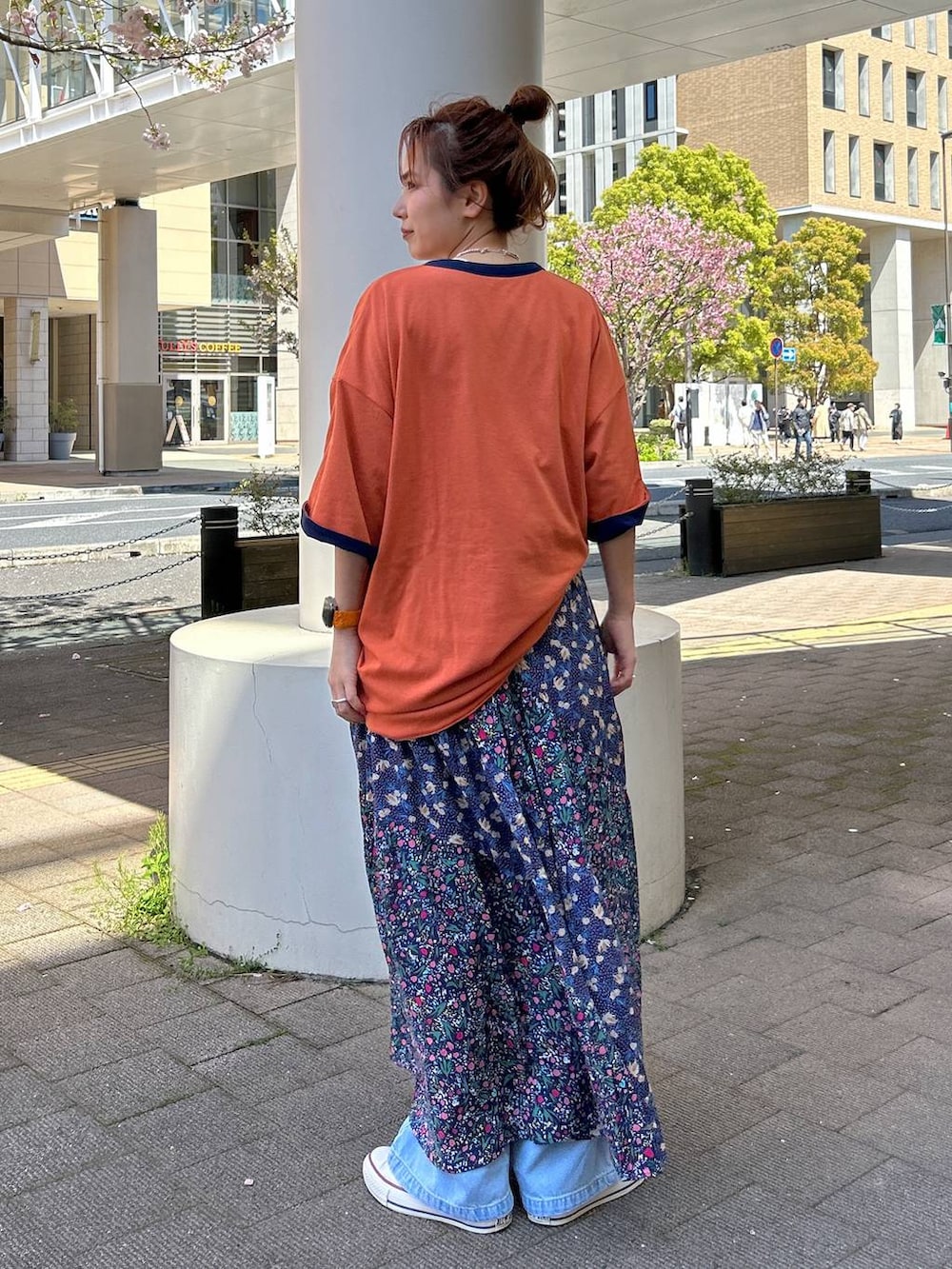 ブルー系のスカート、ブラック系のデニムパンツ、ブラック系のシャツ/ブラウスを着用したレディースの春コーディネートの4枚目の写真