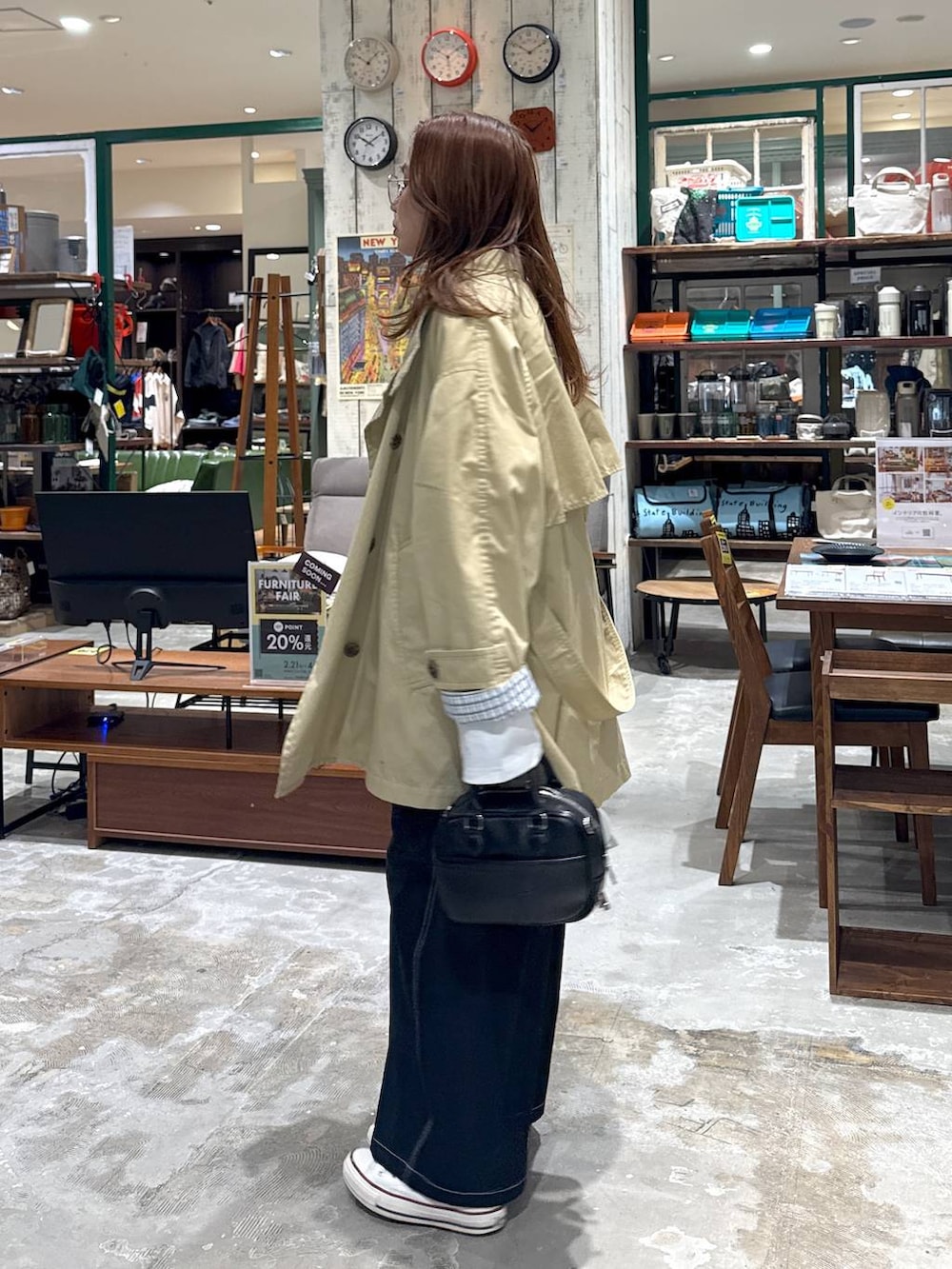 ベージュ系のトレンチコート、ブラック系のボストンバッグを着用したレディースの冬コーディネートの3枚目の写真