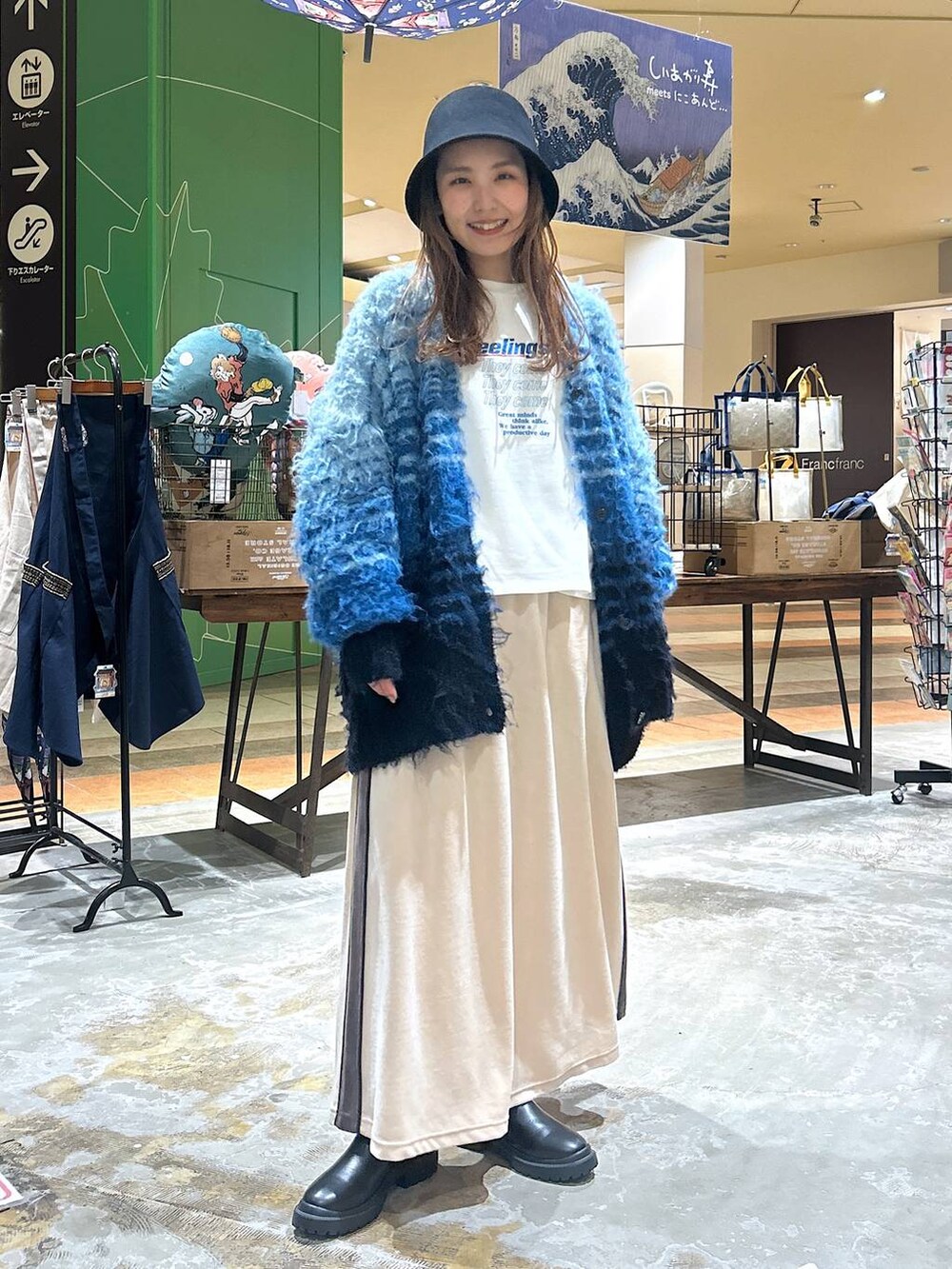 ブラック系のブーツ、ホワイト系のその他トップス、ベージュ系のスカートを着用したレディースの冬コーディネートの2枚目の写真