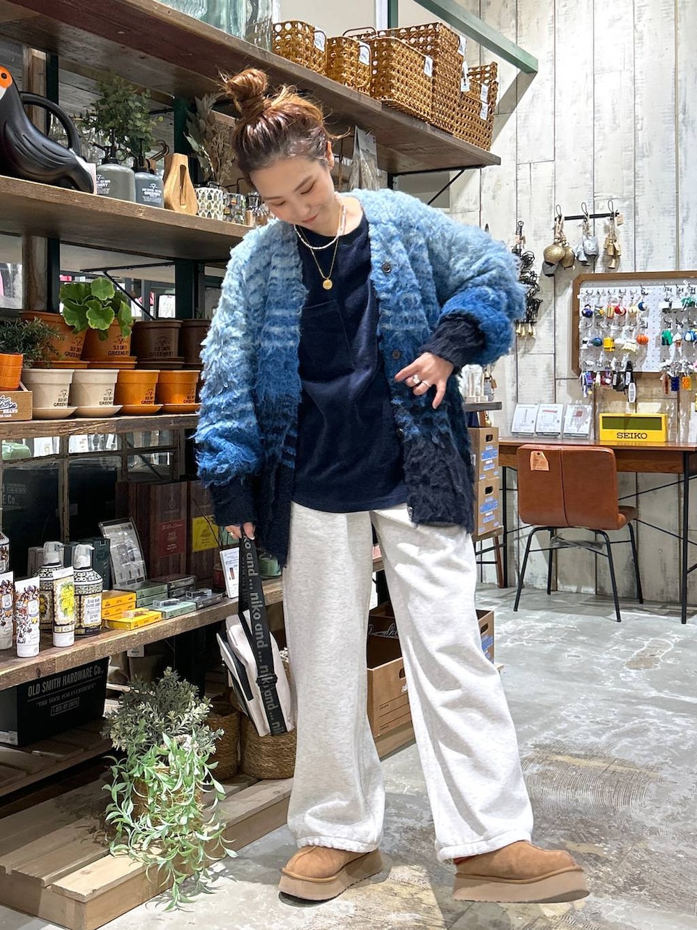 イエロー系のショルダーバッグ、ベージュ系のスウェットパンツ、ブルー系のその他トップスを着用したレディースの冬コーディネートの2枚目の写真