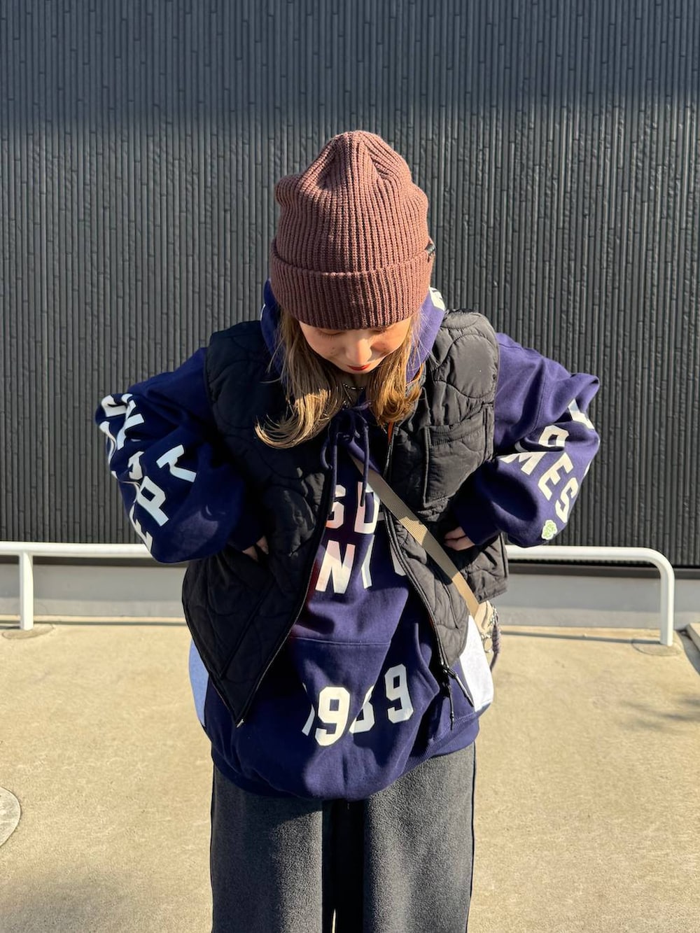 ブラック系のベスト、グレー系のその他パンツ、ブルー系のパーカーを着用したレディースの秋コーディネートの3枚目の写真