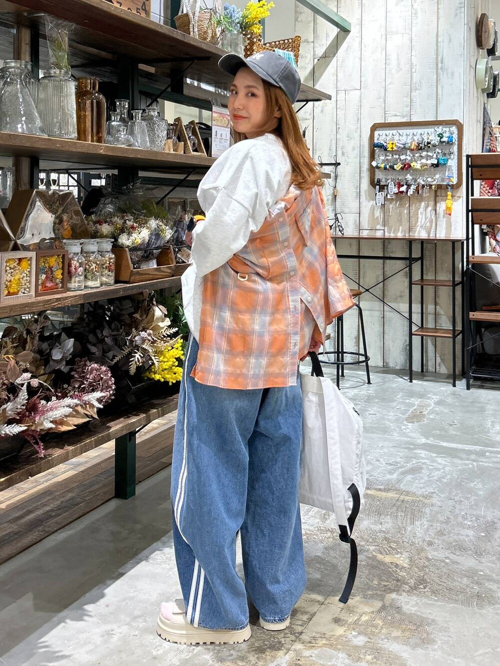 ベージュ系のバックパック/リュック、オレンジ系のシャツ/ブラウス、グレー系のTシャツ/カットソーを着用したレディースの春コーディネートの3枚目の写真