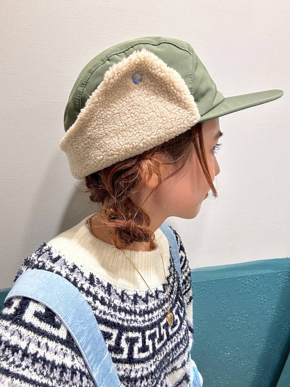 ブルー系のその他パンツ、ベージュ系のニット/セーター、グリーン系のキャップを着用したレディースの冬コーディネートの3枚目の写真