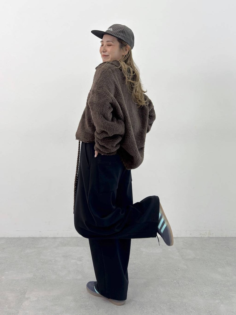 ブラック系のその他パンツ、ブラウン系のポロシャツ、ブラウン系のベルトを着用したレディースの秋コーディネートの3枚目の写真