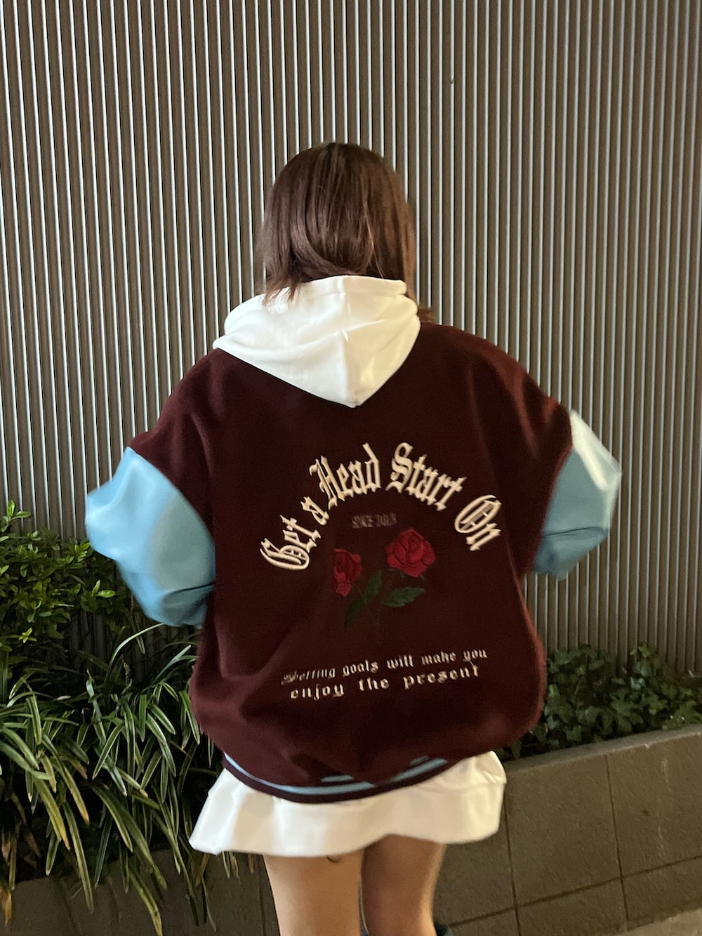 ブルー系のブーツ、レッド系のスタジャン、ホワイト系のパーカーを着用したレディースの冬コーディネートの6枚目の写真