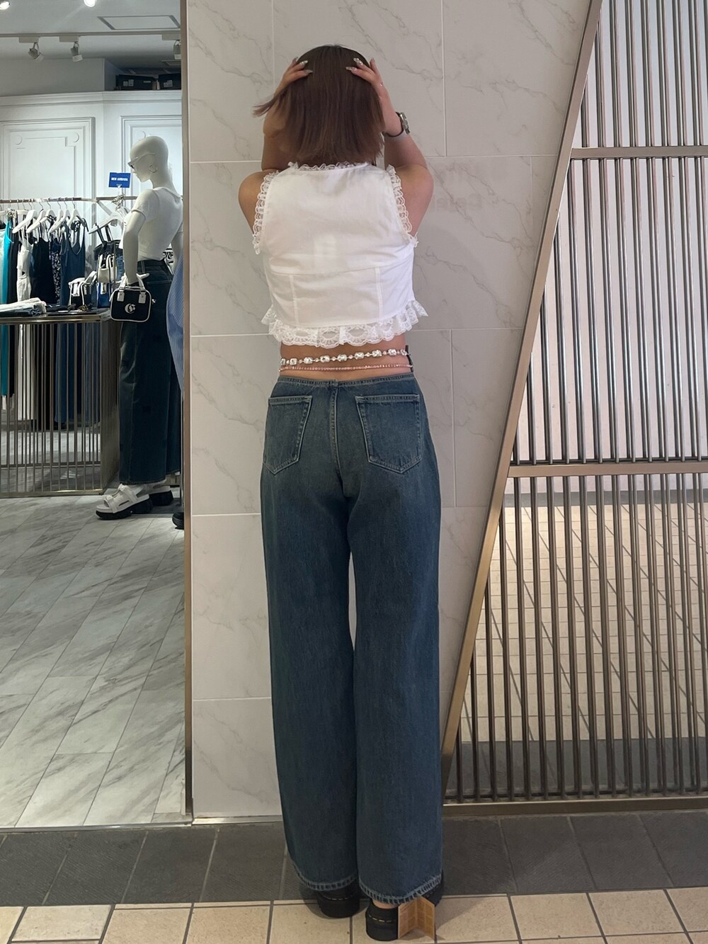 ホワイト系のシャツ/ブラウス、ホワイト系のキャミソール、ブルー系のデニムパンツを着用したレディースの夏コーディネートの3枚目の写真