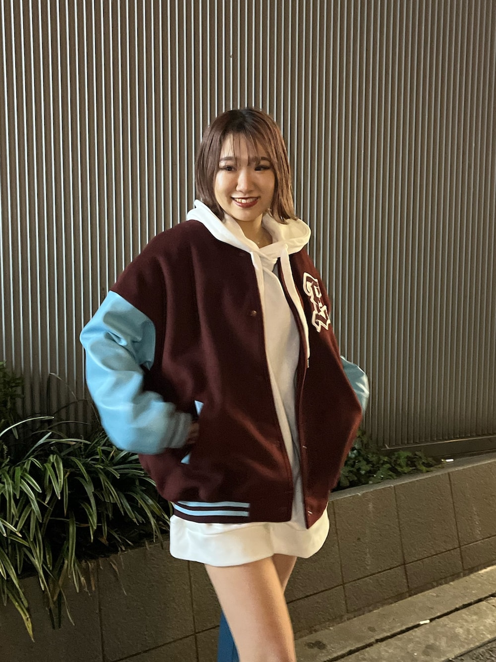 ブルー系のブーツ、レッド系のスタジャン、ホワイト系のパーカーを着用したレディースの冬コーディネートの5枚目の写真