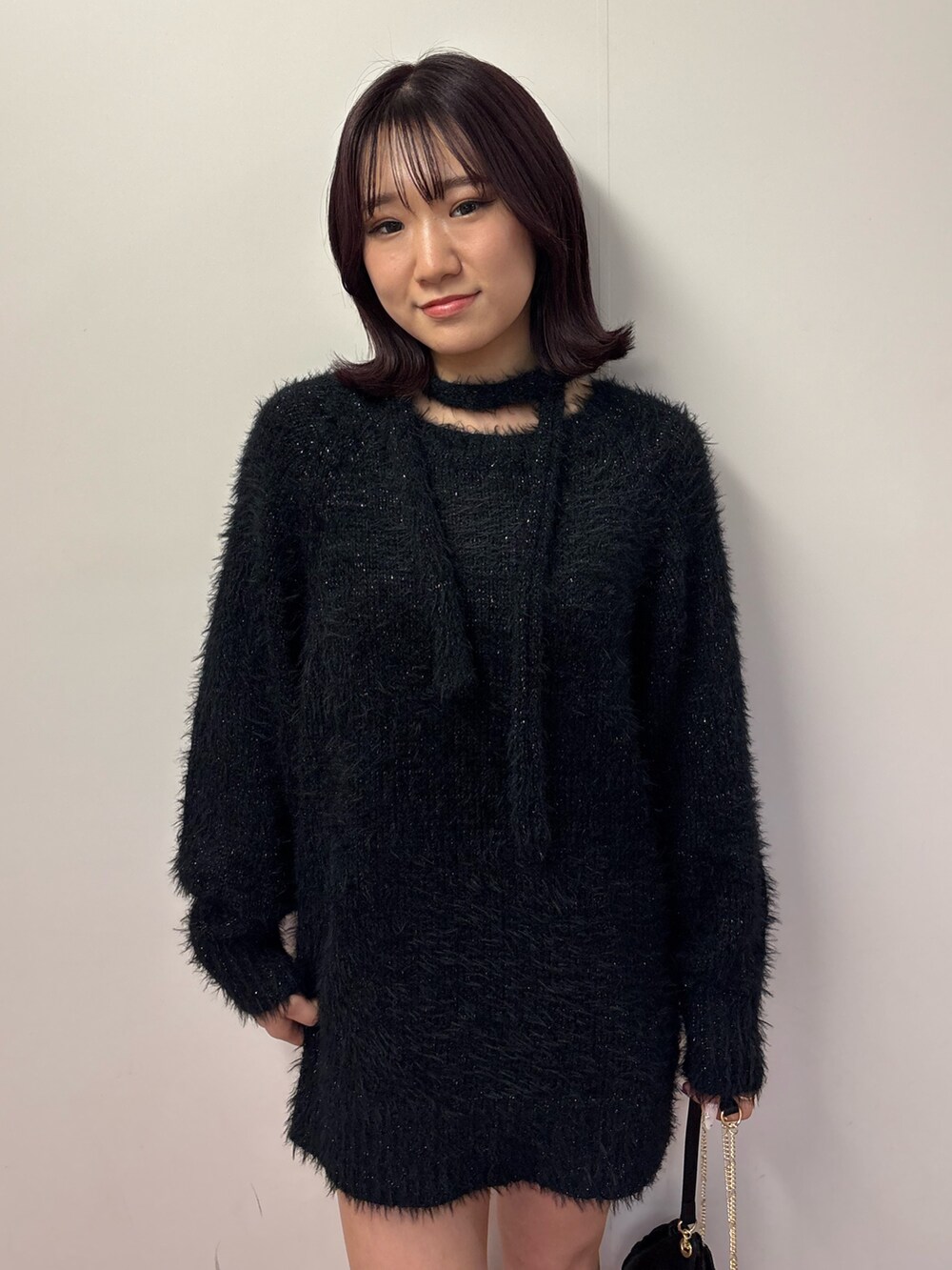 ブラック系のワンピース、ブラック系のショルダーバッグ、グリーン系のブーツを着用したレディースの冬コーディネートの4枚目の写真