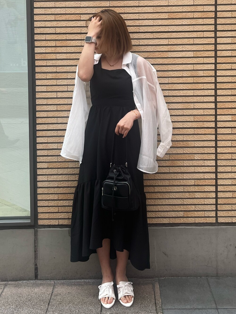 ブラック系のワンピース、ホワイト系のシャツ/ブラウス、ブラック系のショルダーバッグを着用したレディースの夏コーディネートの2枚目の写真