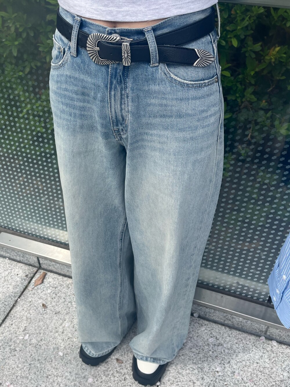 ブラック系のショルダーバッグ、ブルー系のシャツ/ブラウス、ブルー系のデニムパンツを着用したレディースの春コーディネートの7枚目の写真