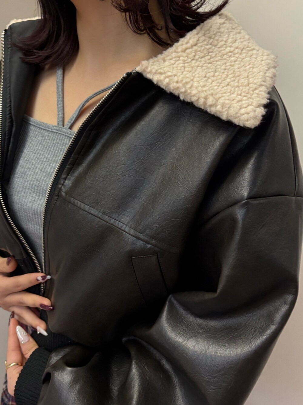 ブラック系のブーツ、ブルー系のスカート、ブラック系のブルゾンを着用したレディースの冬コーディネートの5枚目の写真