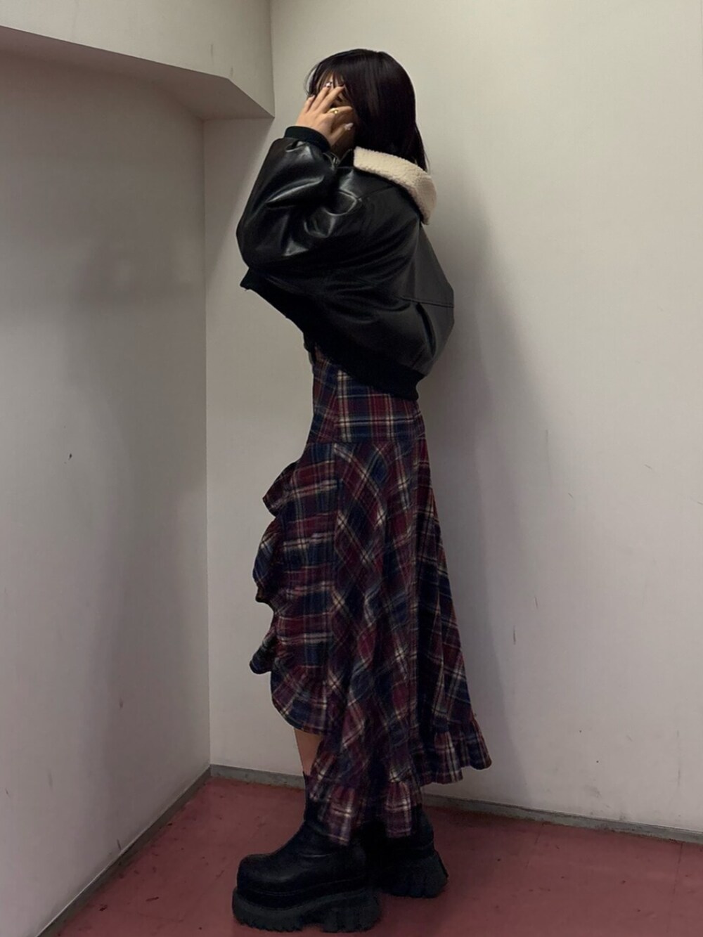 ブラック系のブーツ、ブルー系のスカート、ブラック系のブルゾンを着用したレディースの冬コーディネートの3枚目の写真