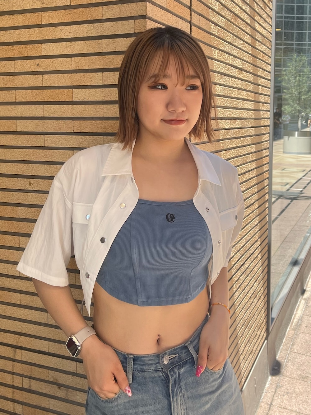 ブルー系のデニムパンツ、ブラック系のサンダル、ブルー系のキャミソールを着用したレディースの夏コーディネートの5枚目の写真