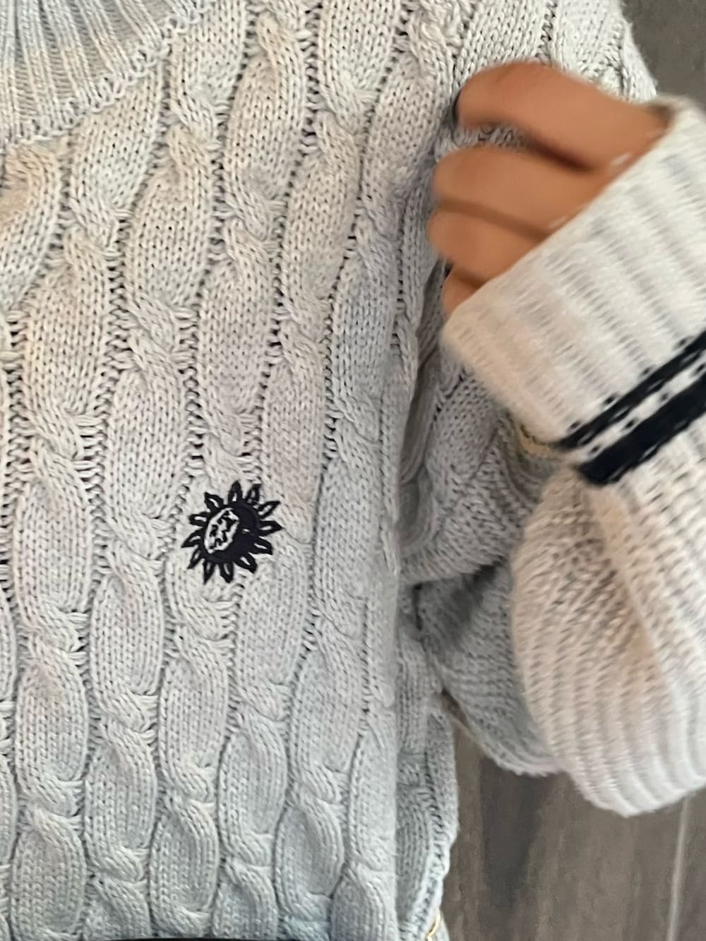 グレー系のニット/セーター、ブラック系のショルダーバッグ、ブラック系のブーツを着用したレディースの秋コーディネートの7枚目の写真