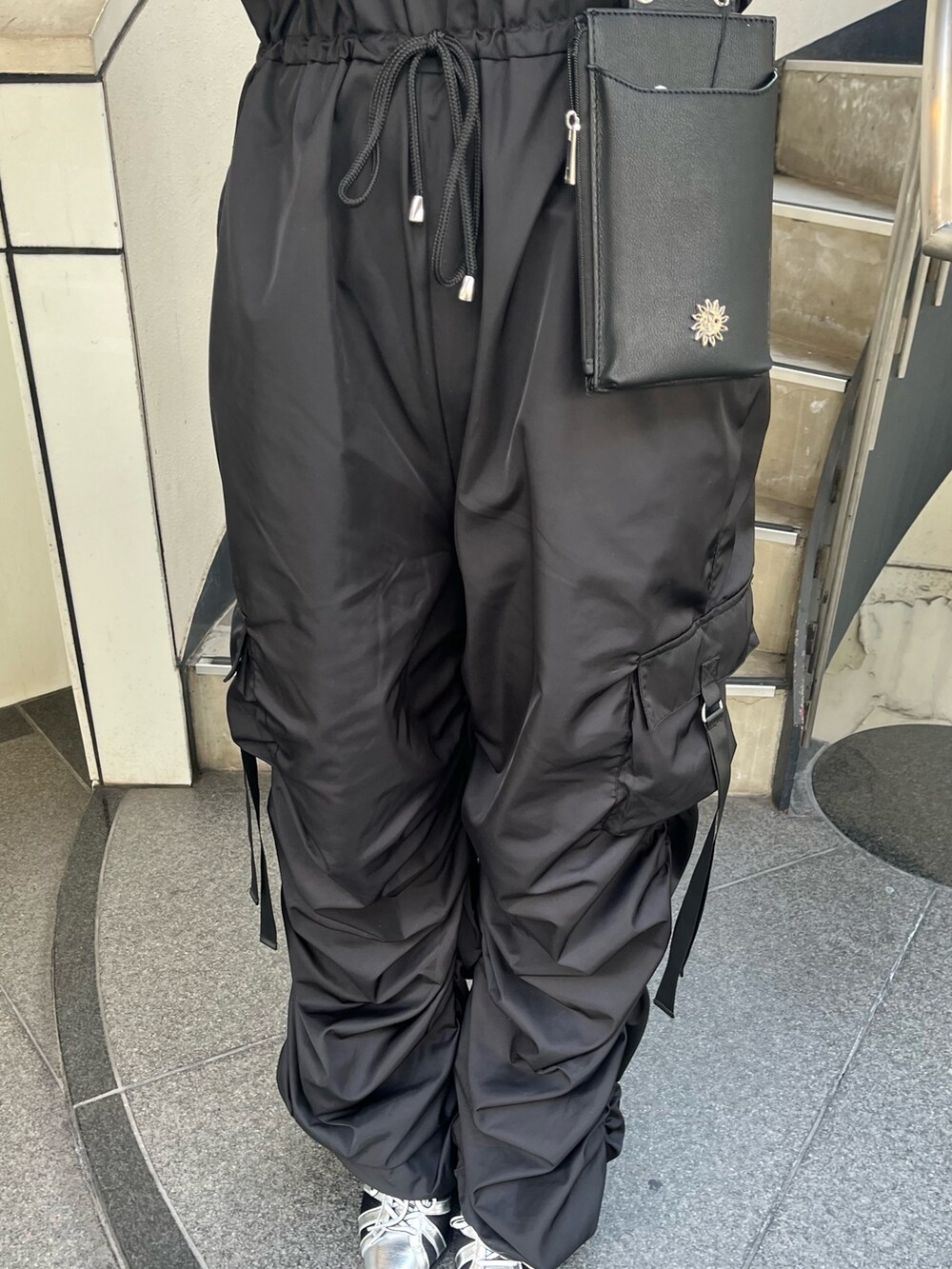 ブラック系のつなぎ/オールインワン、シルバー系のサンダル、ブラック系のショルダーバッグを着用したレディースの春コーディネートの7枚目の写真