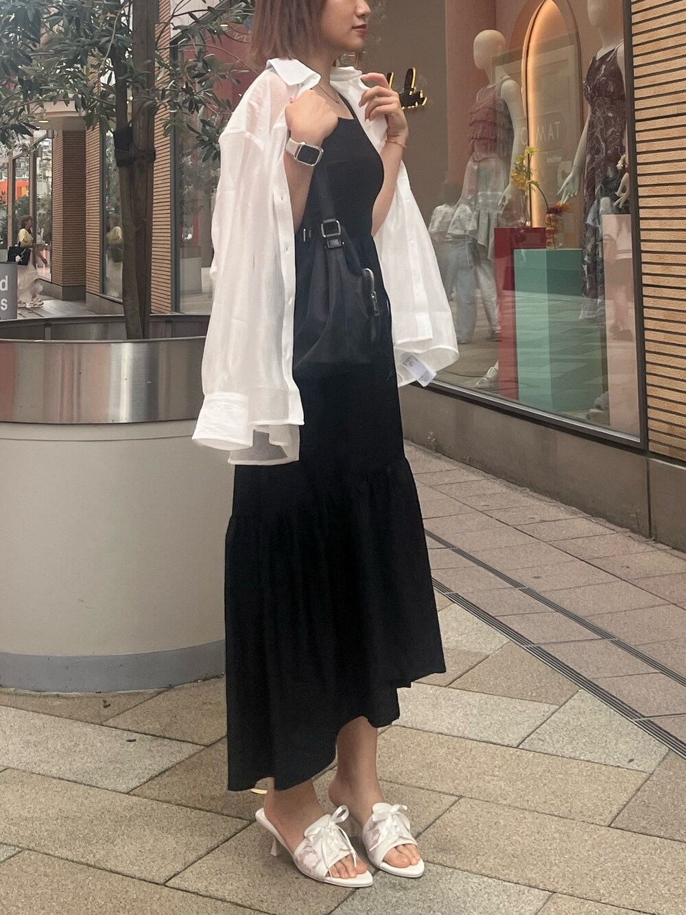 ブラック系のワンピース、ホワイト系のシャツ/ブラウス、ブラック系のショルダーバッグを着用したレディースの夏コーディネートの3枚目の写真