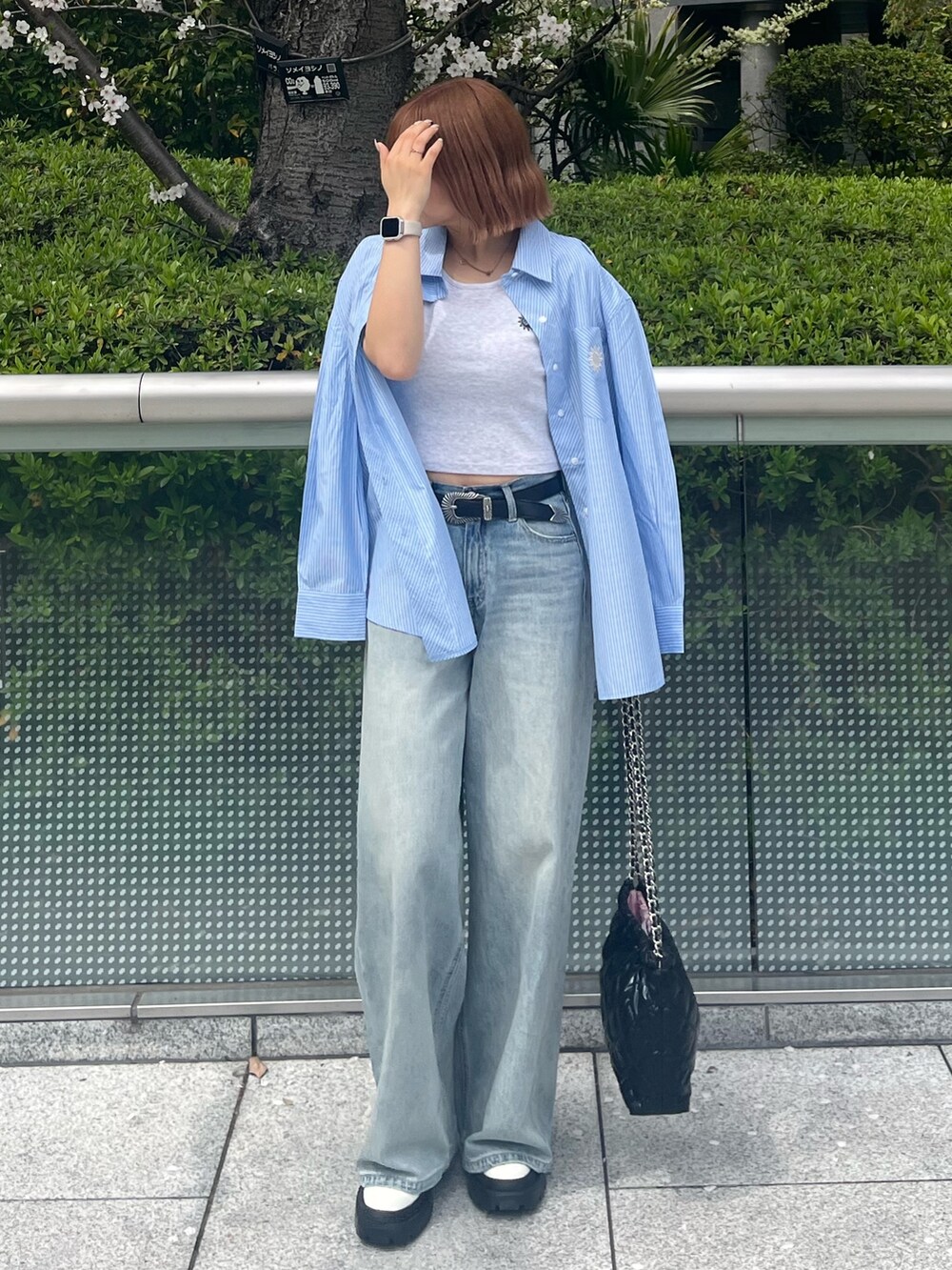 ブラック系のショルダーバッグ、ブルー系のシャツ/ブラウス、ブルー系のデニムパンツを着用したレディースの春コーディネートの2枚目の写真