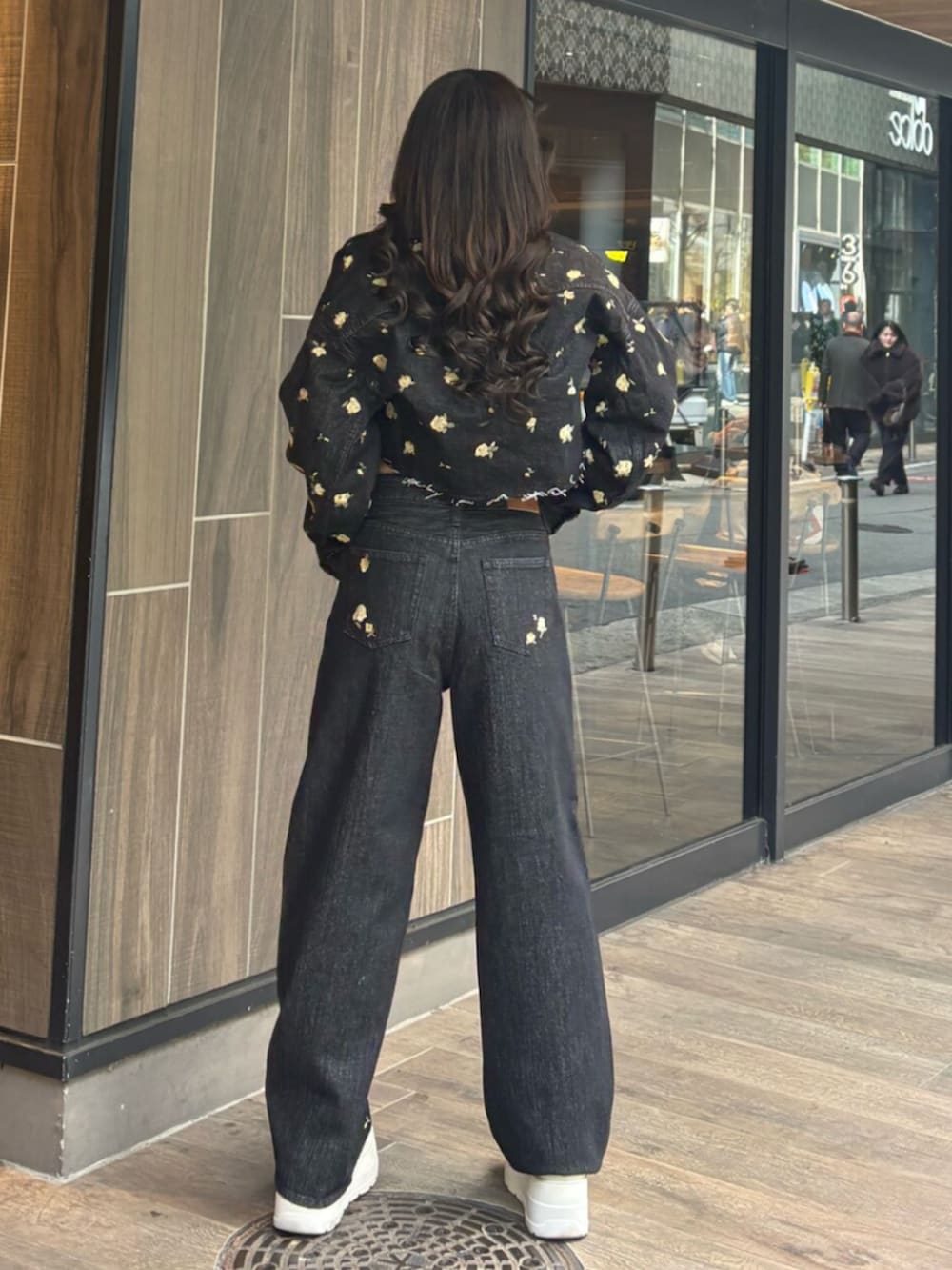 ブラック系のデニムパンツ、ブラック系のデニムジャケット、グレー系のニット/セーターを着用したレディースの冬コーディネートの3枚目の写真