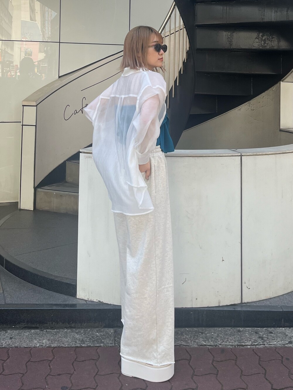 ホワイト系のスウェットパンツ、ホワイト系のサンダル、ブルー系のキャミソールを着用したレディースの春コーディネートの4枚目の写真