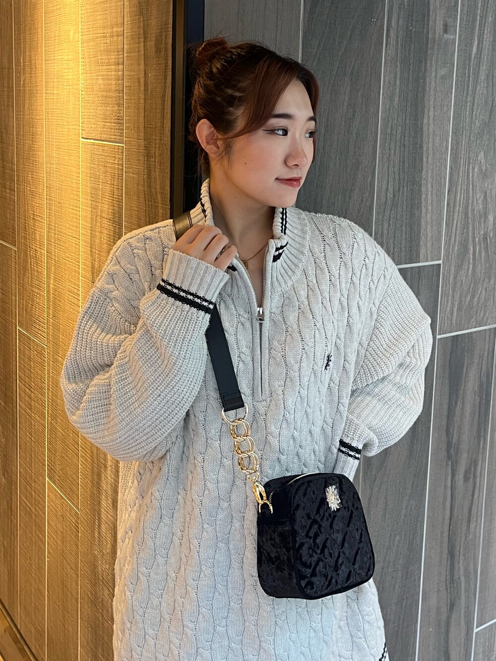 グレー系のニット/セーター、ブラック系のショルダーバッグ、ブラック系のブーツを着用したレディースの秋コーディネートの6枚目の写真