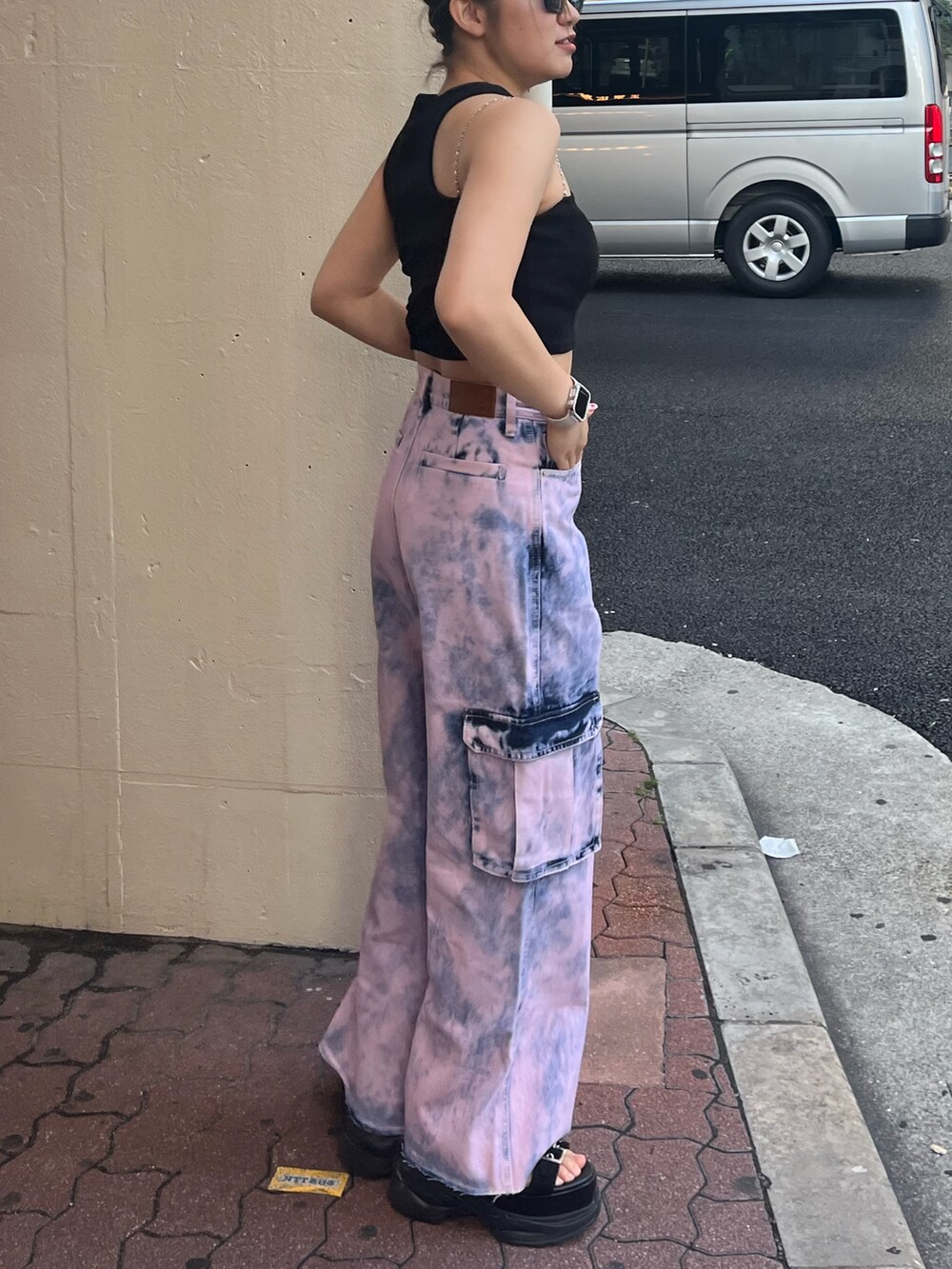 ピンク系のデニムパンツ、ブラック系のサンダル、ブラック系のTシャツ/カットソーを着用したレディースの夏コーディネートの2枚目の写真