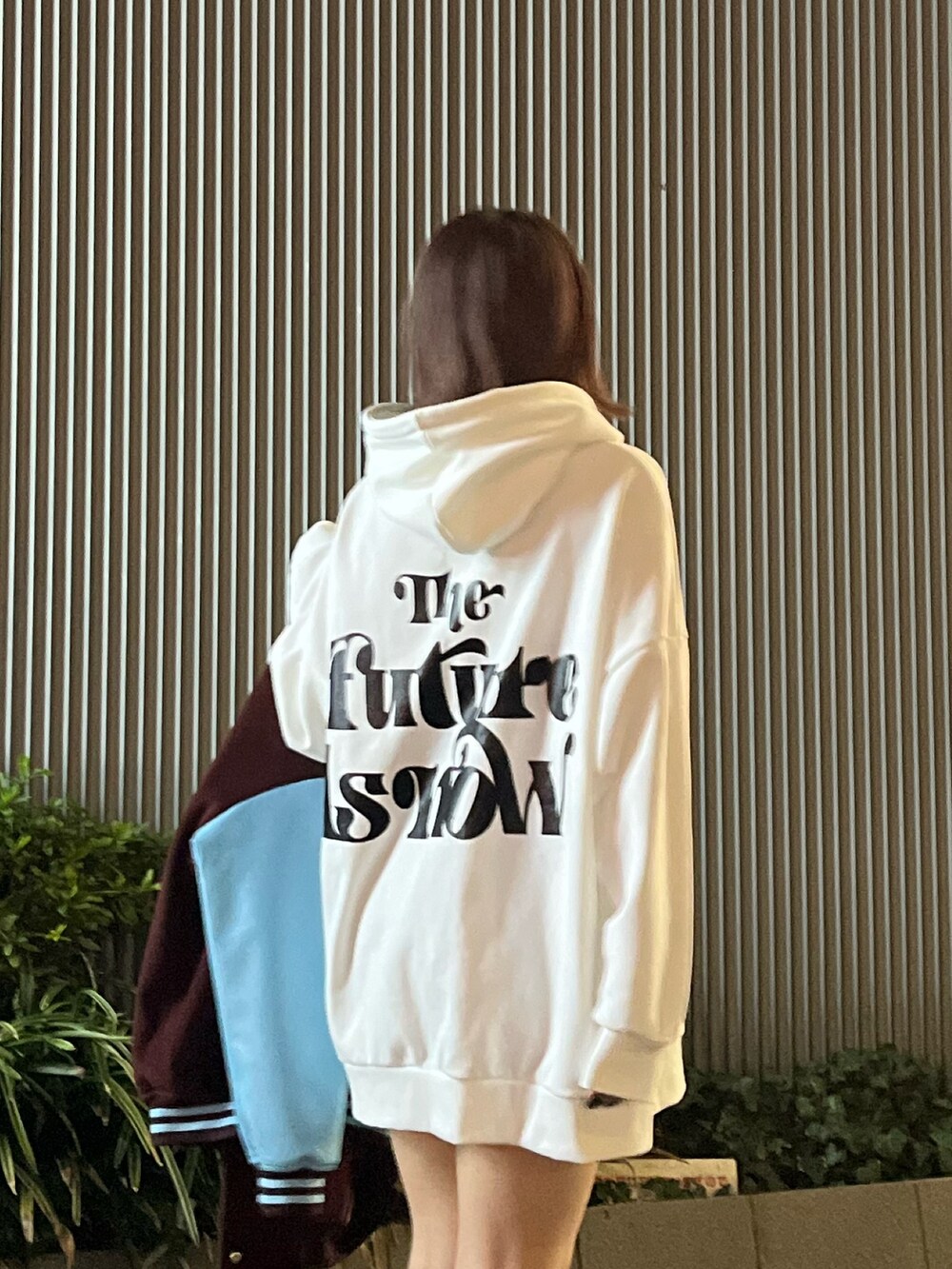 ブルー系のブーツ、レッド系のスタジャン、ホワイト系のパーカーを着用したレディースの冬コーディネートの4枚目の写真