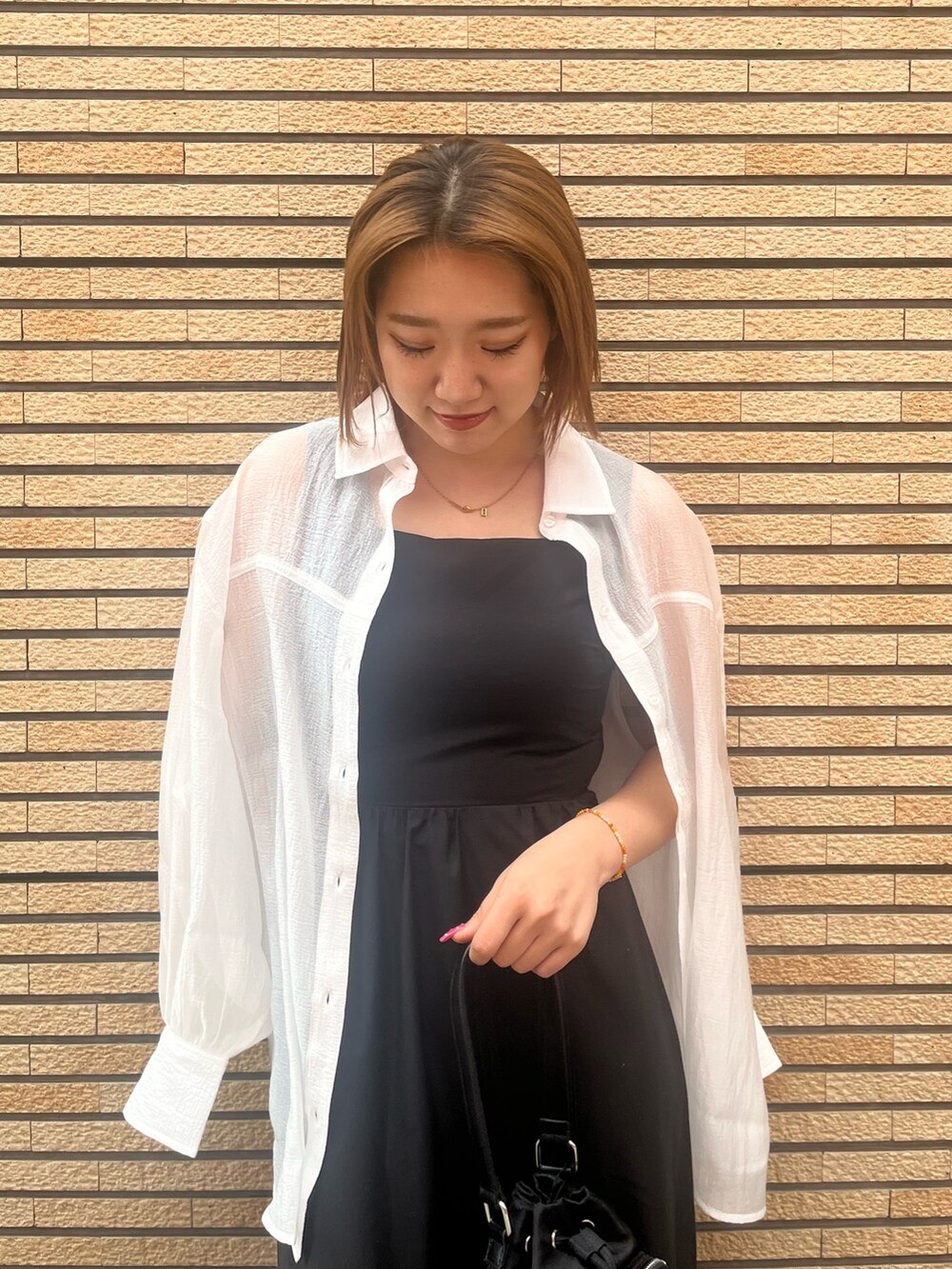 ブラック系のワンピース、ホワイト系のシャツ/ブラウス、ブラック系のショルダーバッグを着用したレディースの夏コーディネートの5枚目の写真