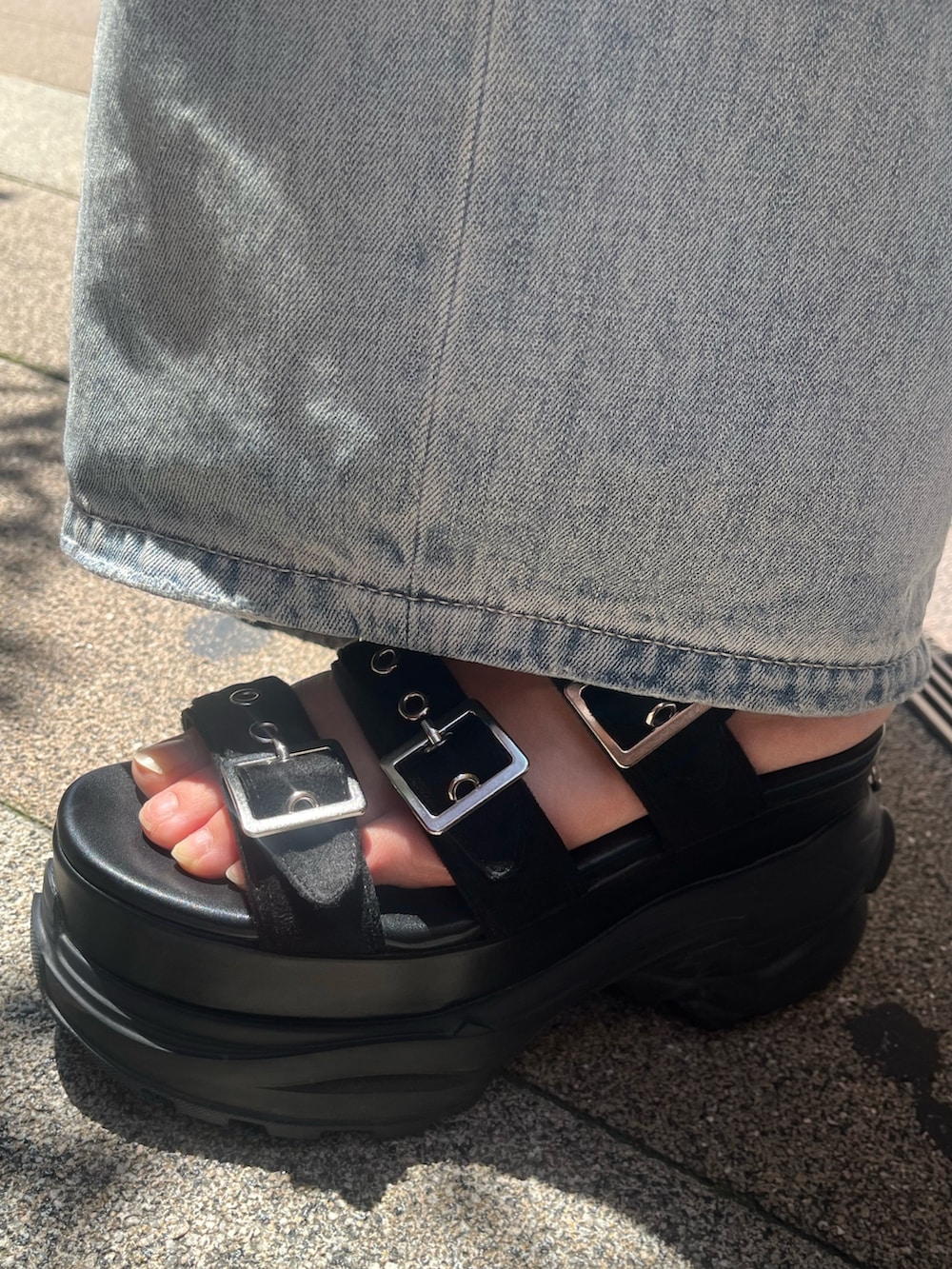 ブルー系のデニムパンツ、ブラック系のサンダル、ブルー系のキャミソールを着用したレディースの夏コーディネートの6枚目の写真