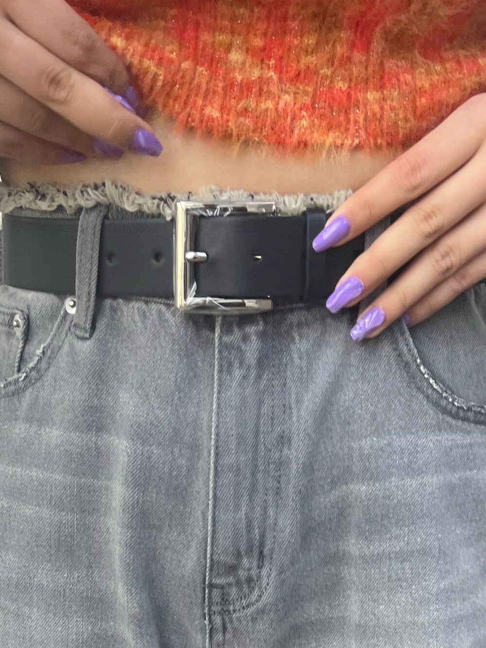 ブラック系のデニムパンツ、ブラック系のブーツ、オレンジ系のニット/セーターを着用したレディースの冬コーディネートの6枚目の写真