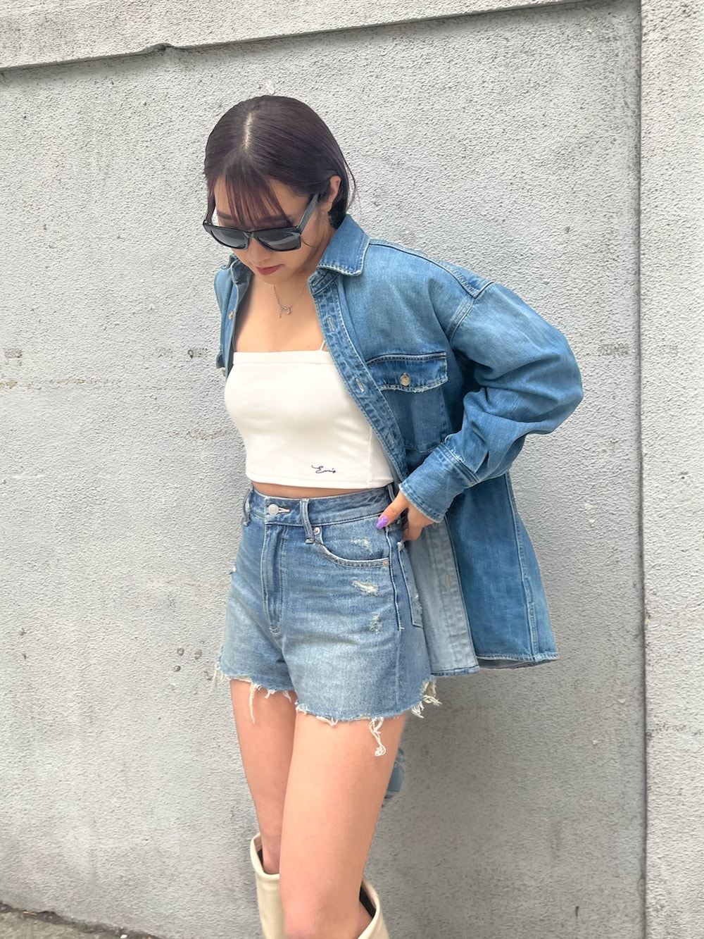 ブルー系のデニムパンツ、ホワイト系のキャミソール、ブルー系のシャツ/ブラウスを着用したレディースの春コーディネートの3枚目の写真