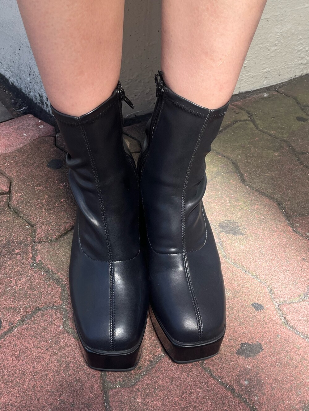 ブラック系のデニムスカート、レッド系のスウェット、ブラック系のブーツを着用したレディースの秋コーディネートの9枚目の写真