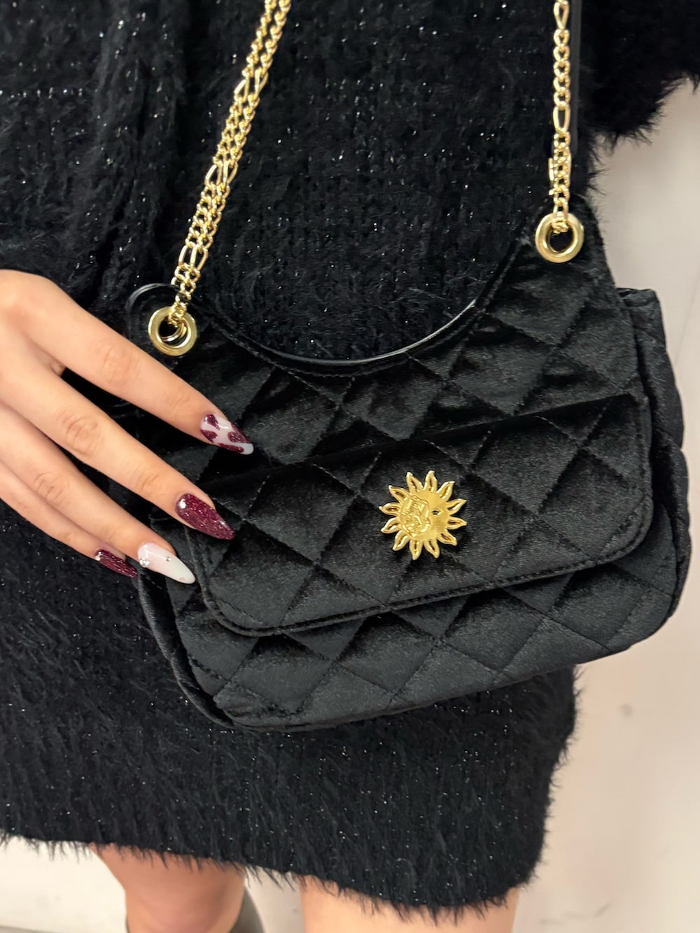 ブラック系のワンピース、ブラック系のショルダーバッグ、グリーン系のブーツを着用したレディースの冬コーディネートの5枚目の写真